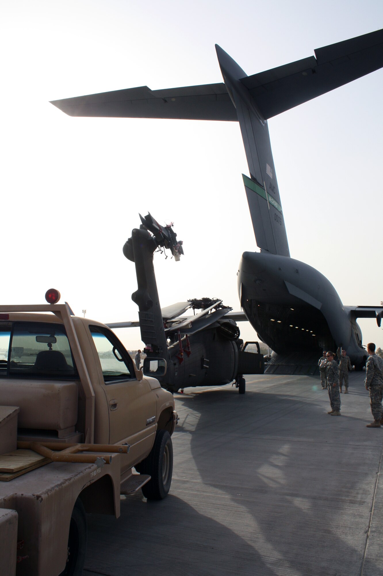 An Army UH-60 Blackhawk helicopter is loaded onto a waiting C-17 Globemaster III for transport to locations in areas of higher priority July 12, 2010, at Joint Base Balad, Iraq.  Approximately 70 helicopters have transitioned through Balad for redeployment of U.S. forces from Iraq. (U.S. Air Force photo/Staff Sgt. Stacy Fowler)