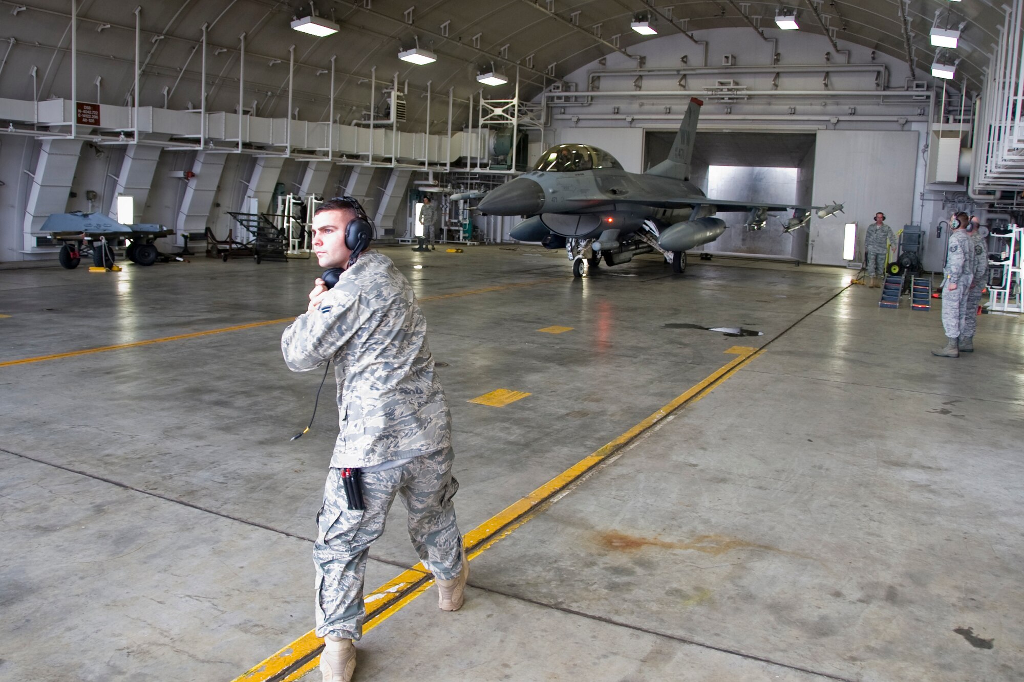 MISAWA AIR BASE, Japan -- Senior Airman Christopher Feebes, 35th Aircraft Maintenance Unit crew chief, marshals Col. David Stilwell, 35th Fighter Wing commander, out of a hardened aircraft shelter July 14. The flight was Colonel Stilwell's final flight as the wing's commander. (U.S. Air Force photo/Senior Airman Jamal D. Sutter)
