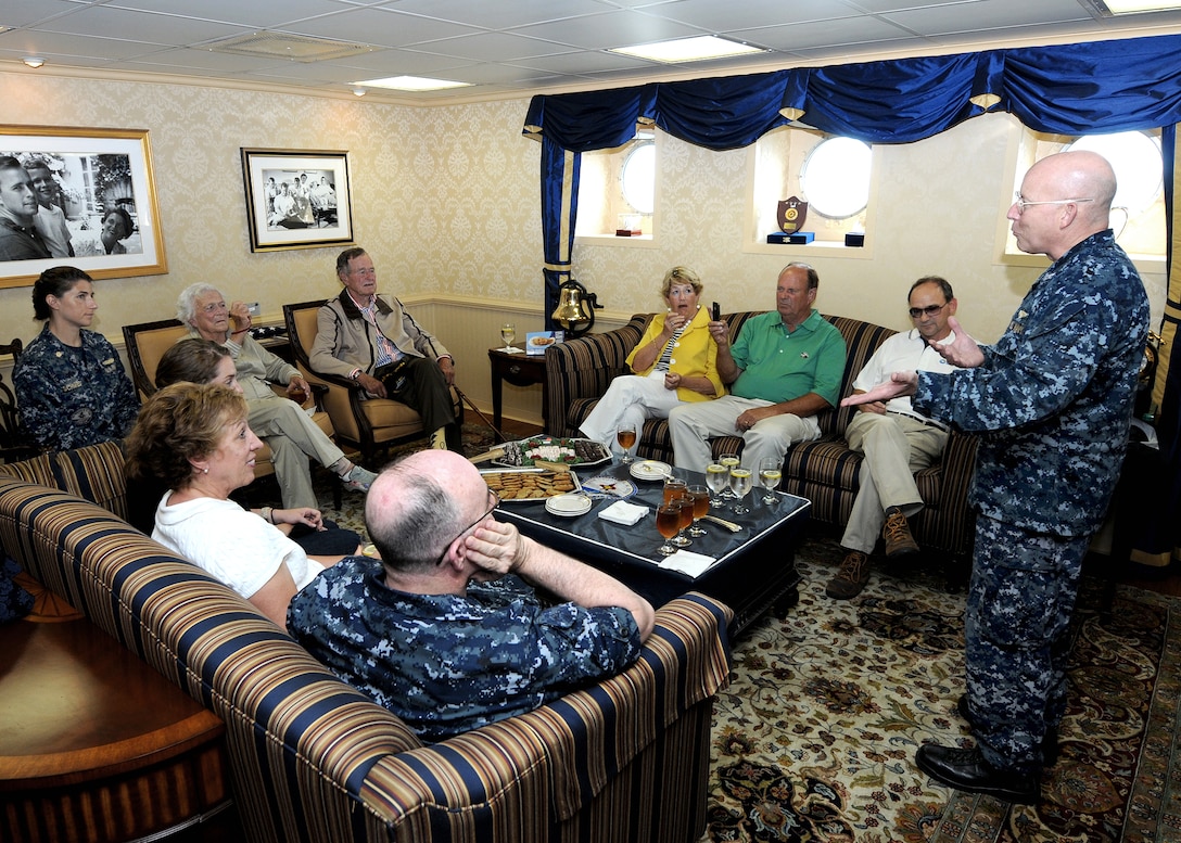 U.S. Navy Capt. Chip Miller, right, commanding officer of the aircraft carrier USS George H.W. Bush, welcomes aboard former President George H.W. Bush and his wife, Barbara, in the Atlantic Ocean, July 14, 2010.