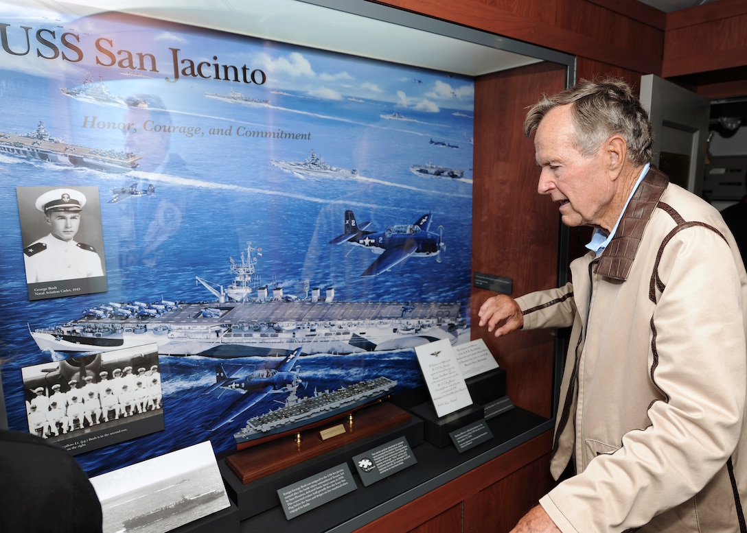 Former President George H.W. Bush looks at a display of his former ship, the USS San Jacinto, in the tribute room of the USS George H.W. Bush, in the Atlantic Ocean, July 15, 2010.
