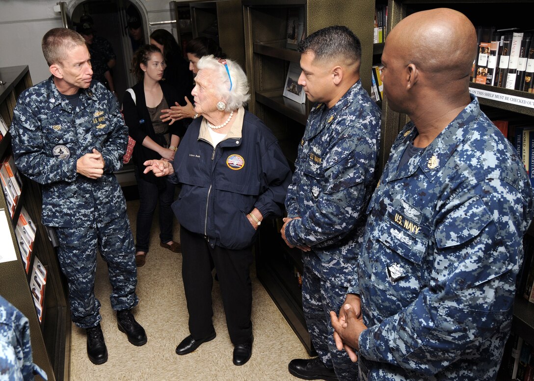 U.S. Navy Cmdr. Cameron Fish and former First Lady Barbara Bush tour the ship's library aboard the George H.W. Bush, in the Atlantic Ocean, July 15, 2010. Fish is a command chaplain.
