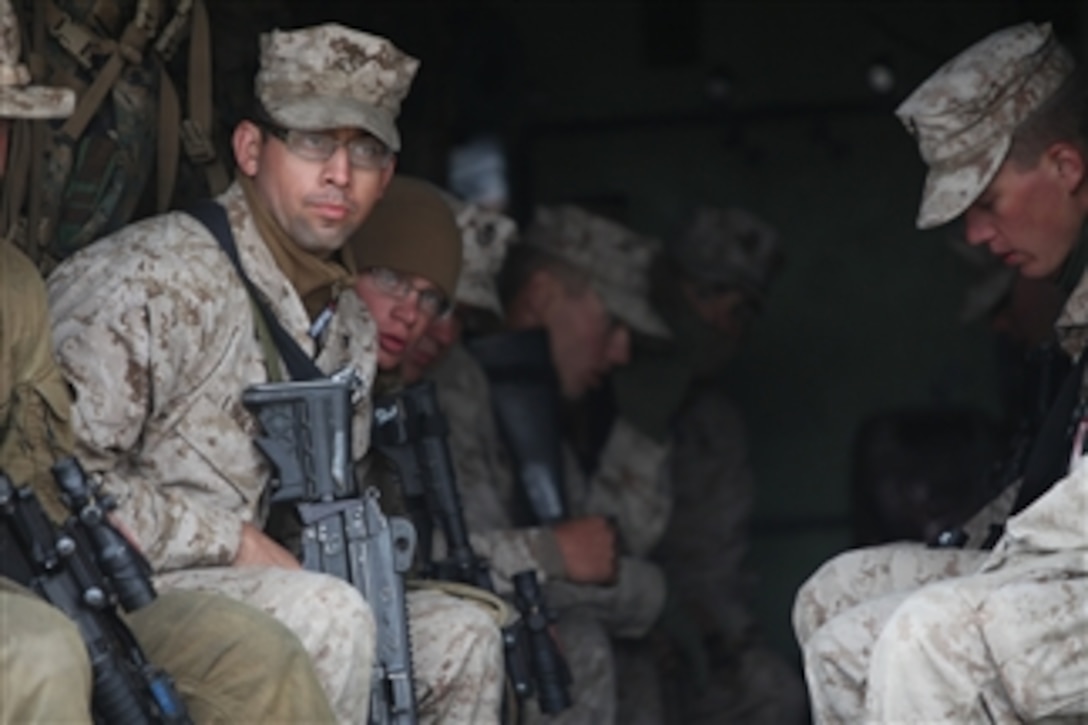 U.S. Marines sit in the back of an amphibious assault vehicle.