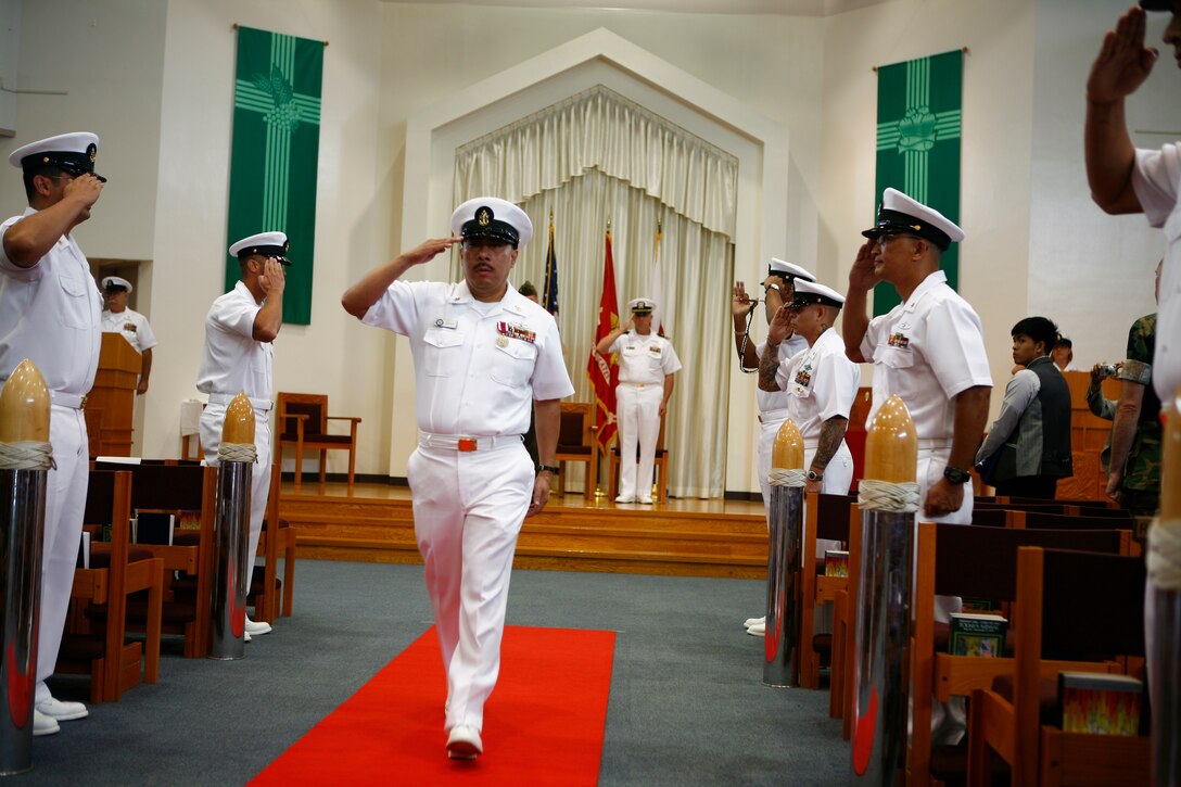 Senior Chief Petty Officer Lemuel G. Oconer, outgoing Harbor Operations Division officer, salutes during his piping ashore as part of his retirement ceremony at the Marine Memorial Chapel here July 16. Oconer served 26 years, and his personal decorations include the Meritorious Service Medal, Navy Commendation Medal and Navy Achievement Medal.