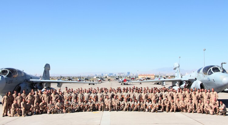 Marines of Marine Tactical Electronic Warfare Squadron 3 gather together between two of their EA-6B Prowlers on the flight line at Nellis Air Force Base, Nev., July 17. VMAQ-3 brought six Prowlers and more than 100 Marines for exercise Red Flag Class 10-4, which was a two-week, advanced aerial combat training exercise.