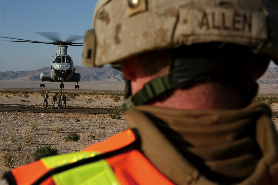 Lance Cpl. Trevor Allen, landing support specialist, Landing Support Platoon, Combat Logistics Battalion 3, 3rd Marine Logistics Group, III Marine Expeditionary Force, directs a CH-46 as it hovers over the Helicopter Support Team during an Enhanced Mojave Viper pre-deployment training evolution at Marine Corps Air-Ground Combat Center Twentynine Palms, Calif., July 15. The Marines were attaching a 450-pound cement block to the helicopter to simulate cargo loads.