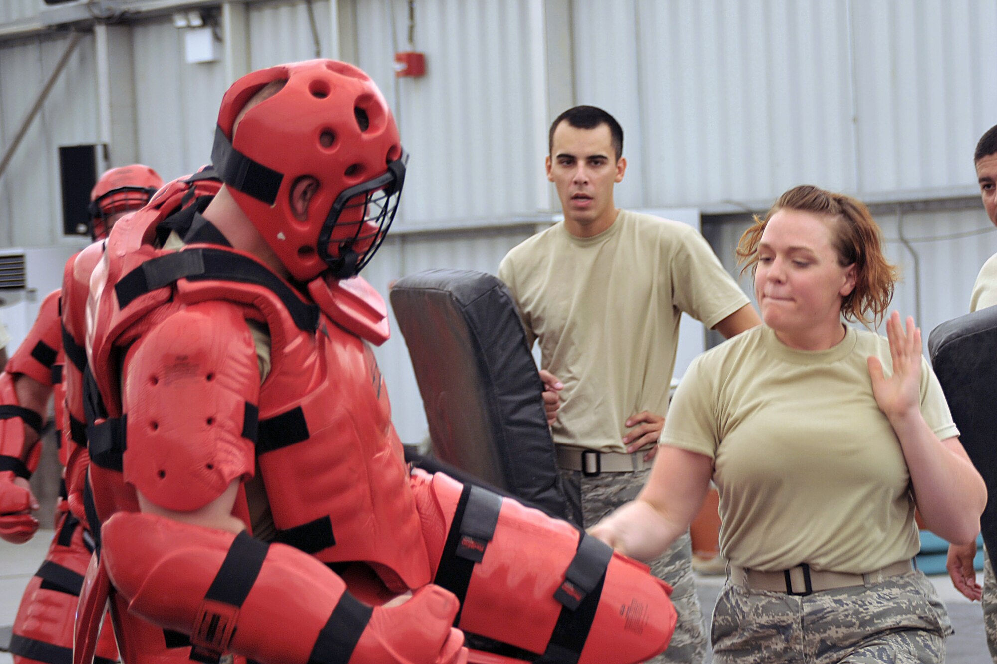 A 380th Expeditionary Security Forces Squadron Airman trains with Senior Airman Christina Inman 380th ESFS Force Protection Airman, while Senior Airman Benjamin Carmona watches, July 16 at an undisclosed location in Southwest Asia. Several ESFS personnel helped train Force Protection Airmen on using an asp for protection. (U.S. Air Force photo/Tech. Sgt. April Wickes) 