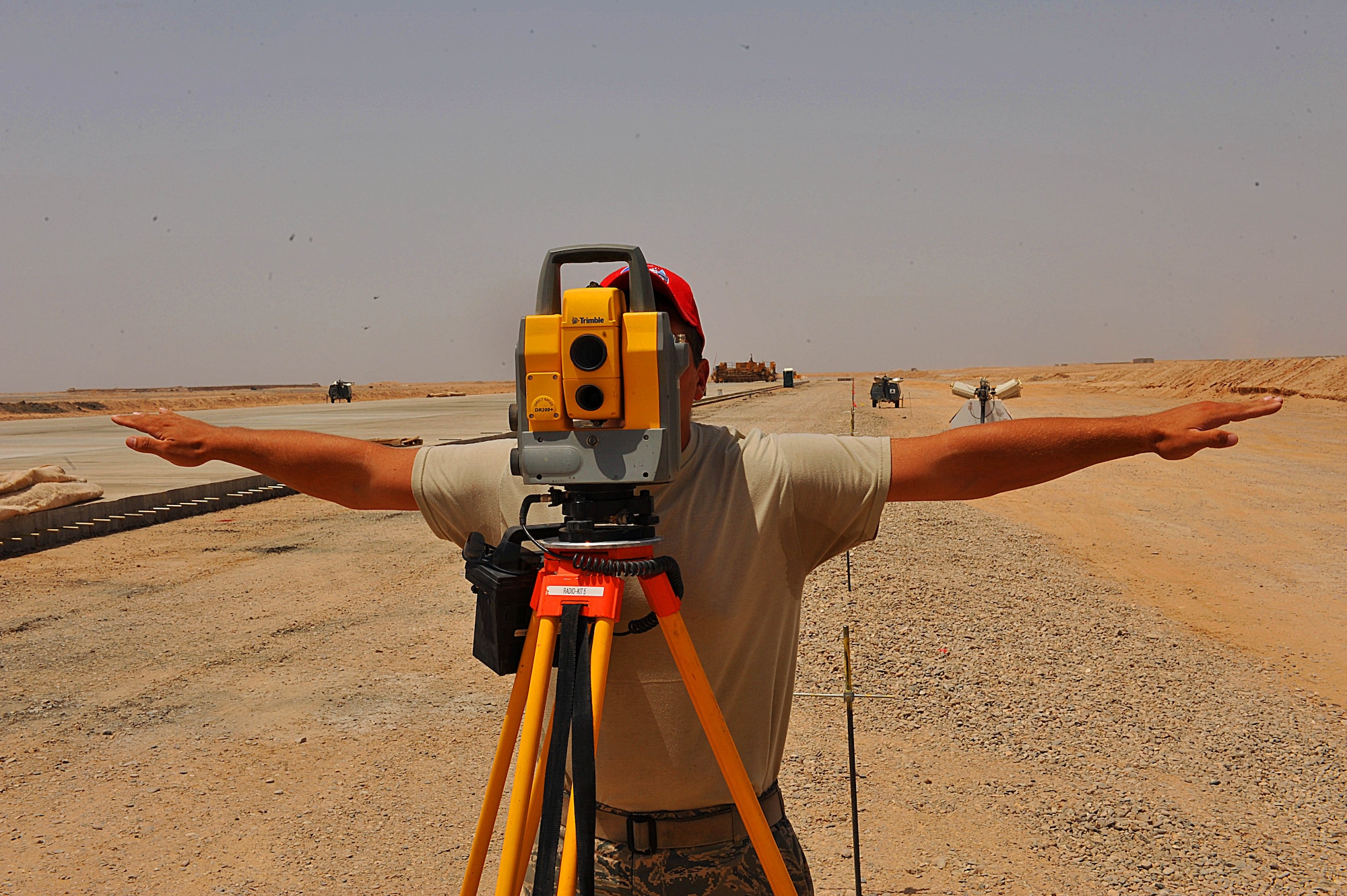 U.S. Air Force Tech. Sgt. Kevin Devore gives directions during an alignment survey on an unfinished runway at Camp Dwyer, Afghanistan, June 25, 2010.  The runway will be used to accommodate heavier aircraft at Camp Dwyer.  Sergeant Devore is an engineer deployed to the 809th Expeditionary Red Horse Squadron.  (U.S. Air Force photo/Staff Sgt. Quinton Russ/released)