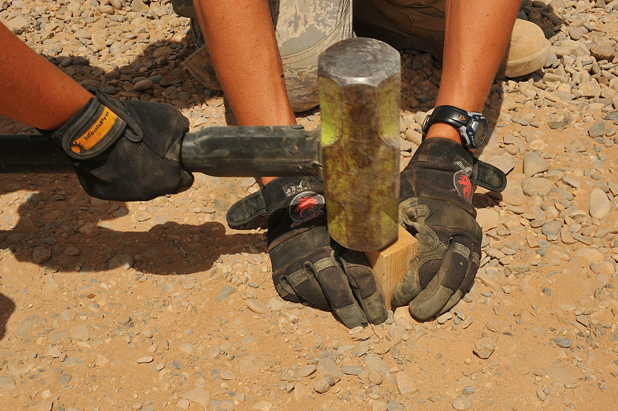 U.S. Air Force Tech. Sgt. Rebecca Walsh, left, and Senior Airman Joseph Carbary hammer a stake for survey alignment on an unfinished runway at Camp Dwyer, Afghanistan, June 25, 2010.  The runway will be used to accommodate heavier aircraft at Camp Dwyer.  Sergeant Walsh and Airman Carbary are engineers deployed to the 809th Expeditionary Red Horse Squadron.  (U.S. Air Force photo/Staff Sgt. Quinton Russ/released)