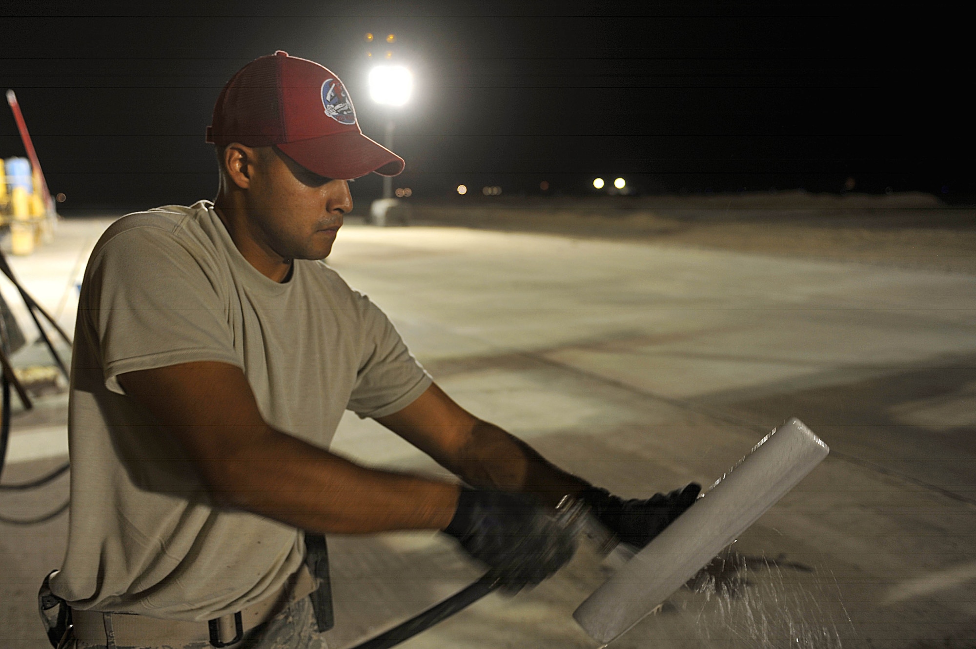 U.S. Air Force Tech. Sgt. Luis Ali cleans a mag flow after being used on newly poured concrete on an unfinished runway at Camp Dwyer, Afghanistan, June 24, 2010.  The runway will be used to accommodate heavier aircraft at Camp Dwyer.  Sergeant Ali is a heavy equipment operator deployed to the 809th Expeditionary Red Horse Squadron.  (U.S. Air Force photo/Staff Sgt. Quinton Russ/released)