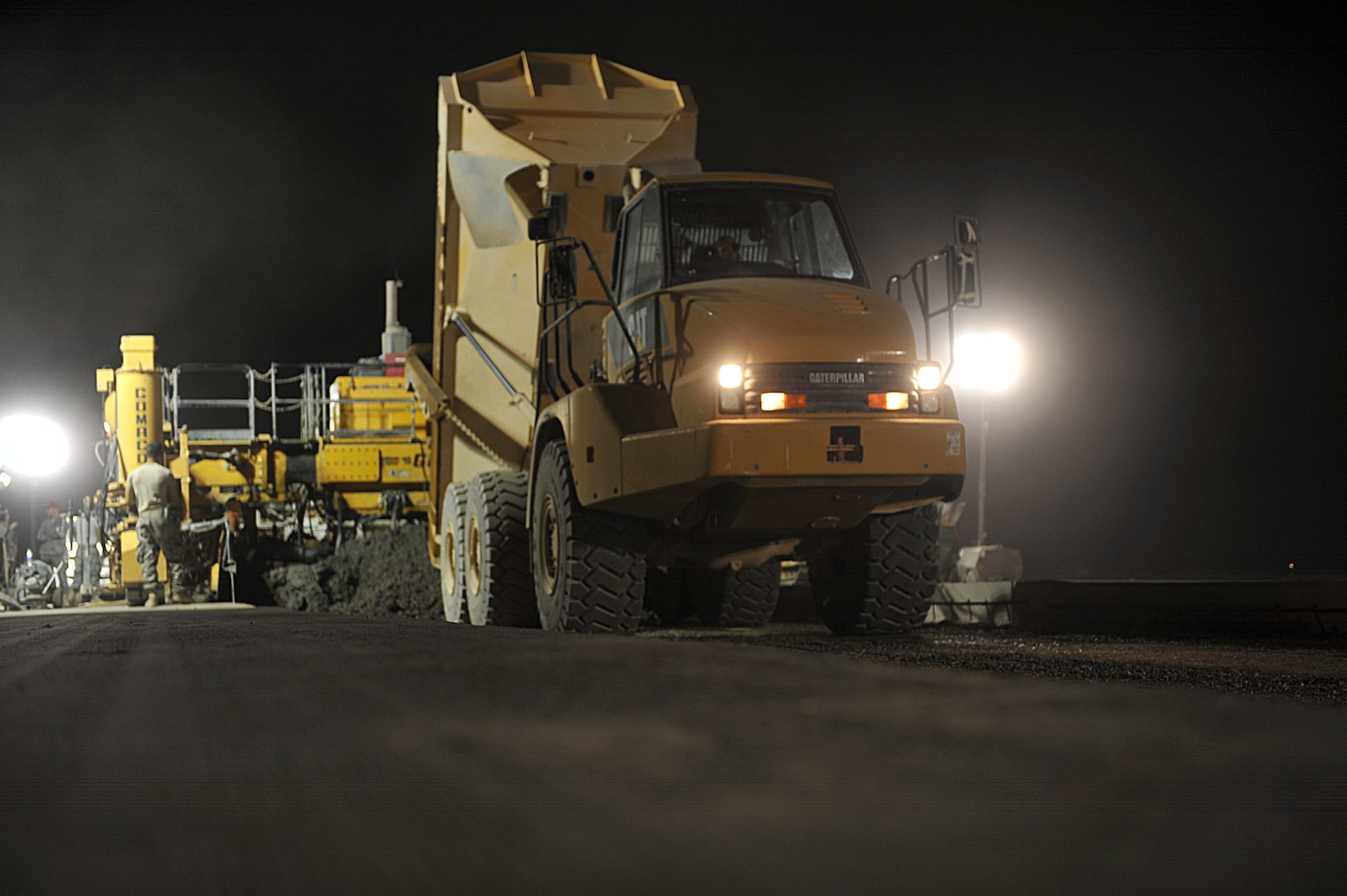 Members of the 809th Expeditionary Red Horse Squadron use a dump truck to pour cement on an unfinished runway at Camp Dwyer, Afghanistan, June 24, 2010.  The runway will be used to accommodate heavier aircraft at Camp Dwyer.  (U.S. Air Force photo/Staff Sgt. Quinton Russ/released)