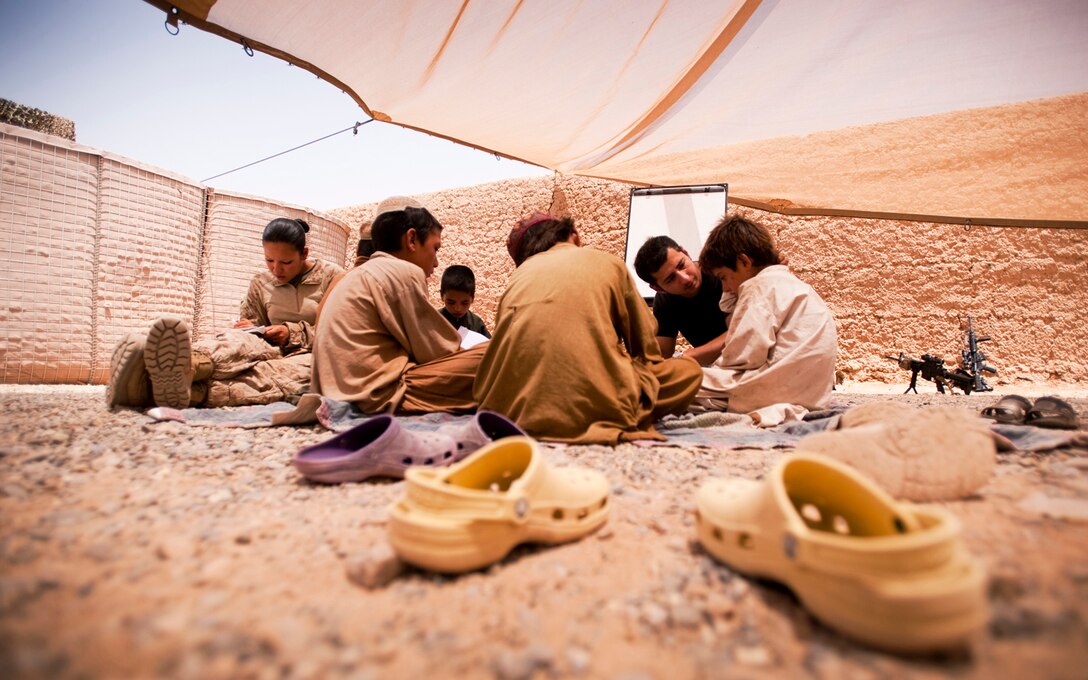 Cpl. Mary Warren and Waheed Mohammed teach Afghan boys during class at the Forward Operating Base Geronimo schoolhouse, July 18, 2010. Most of the kids who attend school are younger than the current war. The children are taught by Marine, Navy and Afghan volunteers. (Official Marine Corps photo by Sgt. Mark Fayloga)