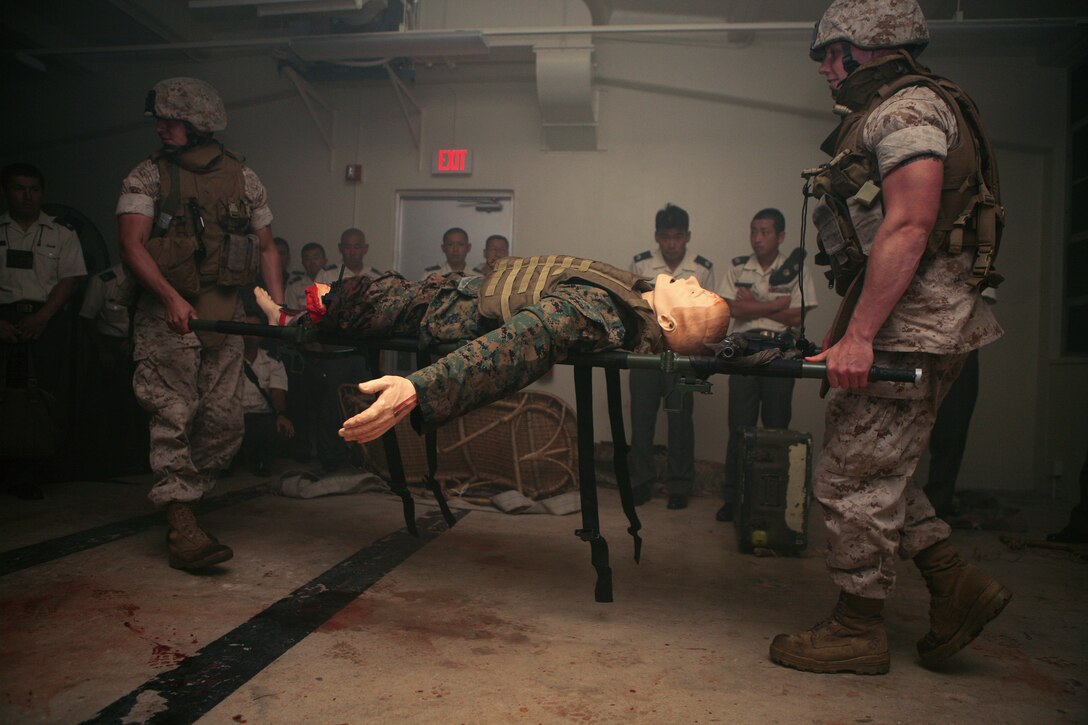 Marines with Truck Company, Headquarters and Service Battalion, 3rd marine Division, III Marine Expeditionary Force, evacuate a mock casualty during a medical demonstration at the III MEF Medical/Trauma Simulation Center July 23.