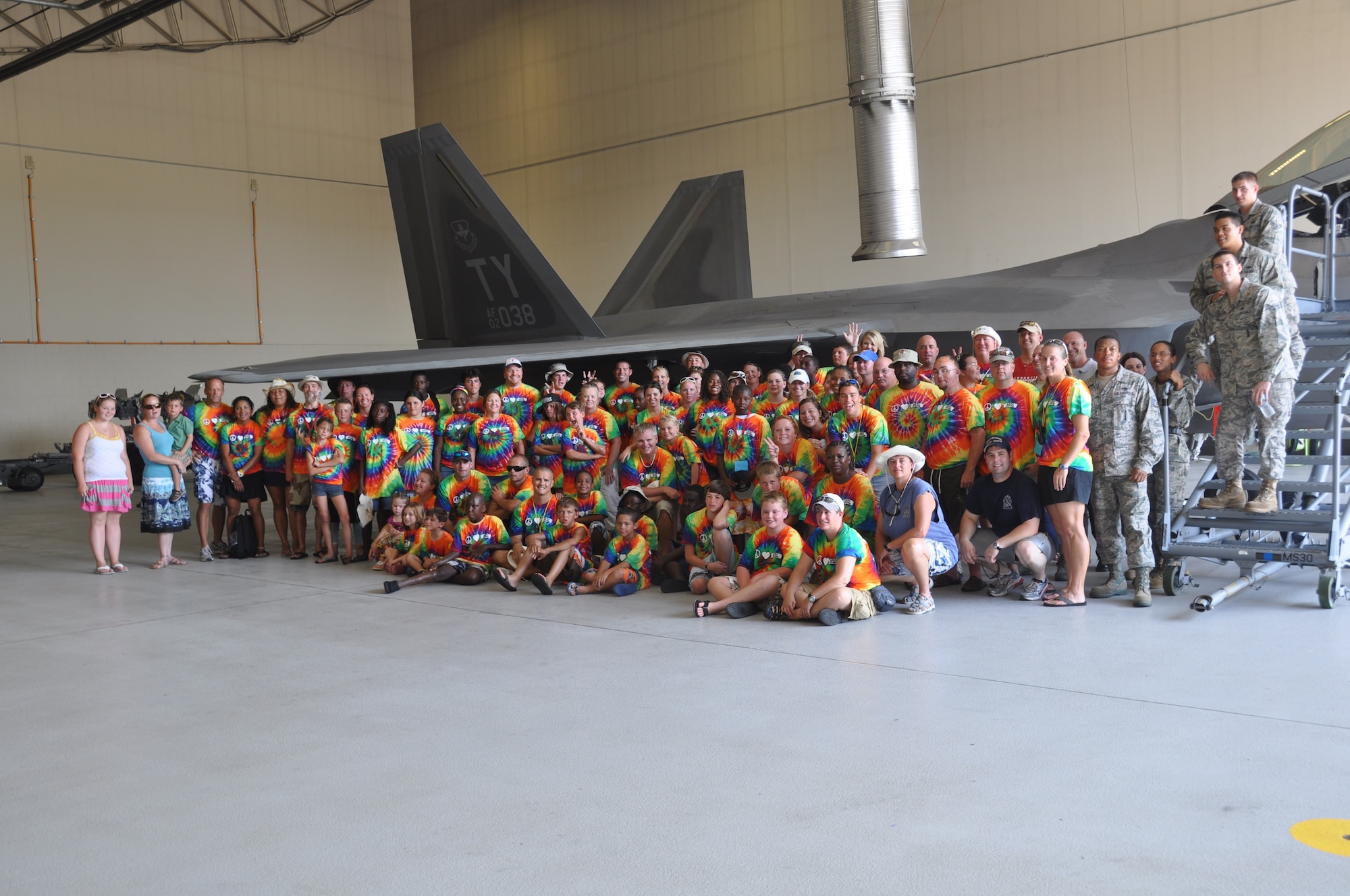 Camp Amigo staff and burn survivors pose for a group photo by a F-22 Raptor while touring Tyndall July 15.  (U.S. Air Force photo/Senior Airman Veronica McMahon)
