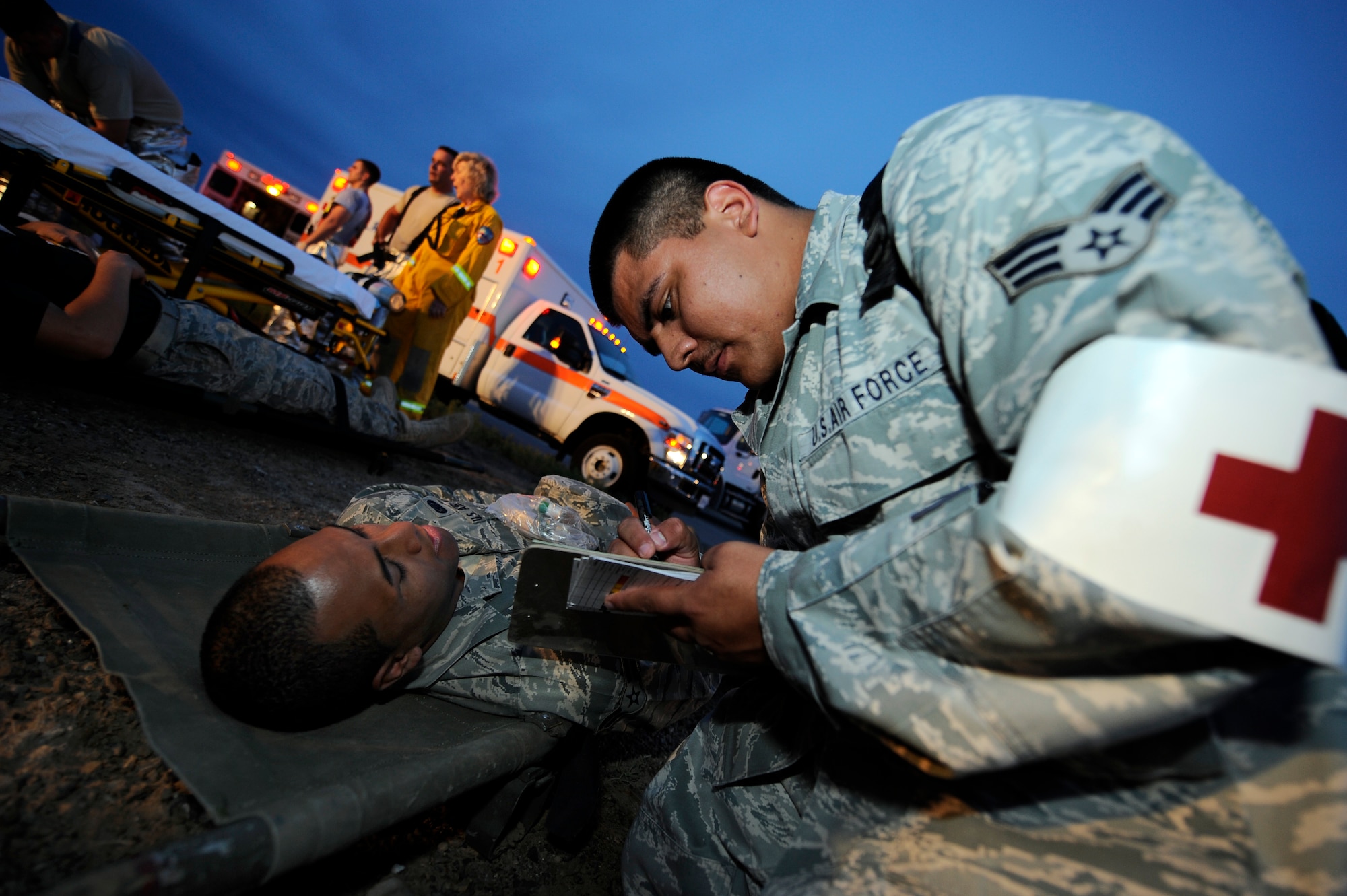 HOLLOMAN AIR FORCE BASE, N.M. -- Senior Airman Carlos Gonzales, 49th Medical Support Squadron, writes down the signs and symptoms of Airman 1st Class Siuta Ika, 49th Wing Public Affairs, during a Major Accident Response Exercise July 15, 2010. More than 37 volunteers were painted with moulage and participated in the exercise scenario to test Holloman's ability to respond to a real-world crisis. (U.S. Air Force photo by Senior Airman Veronica Stamps / Released)