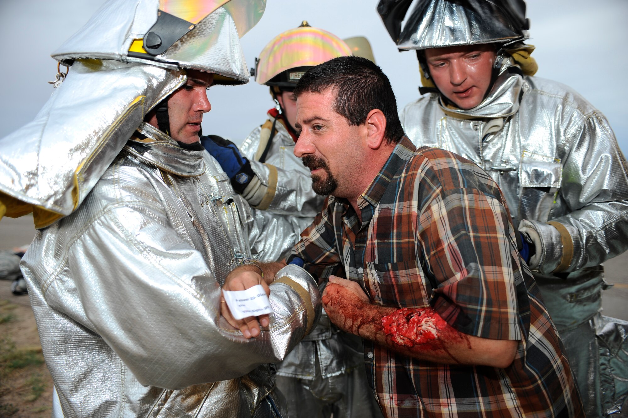 HOLLOMAN AIR FORCE BASE, N.M. -- Airman 1st Class Kevin White and Chad Schumpert, both from the 49th Civil Engineer Squadron Fire Department, carry a simulated victim out of an overturned bus as part of a Major Accident Response Exercise July 15, 2010. The volunteers who played victims held a slip of paper to help the firemen and medics identify their medical conditions. (U.S. Air Force photo by Senior Airman Veronica Stamps / Released)