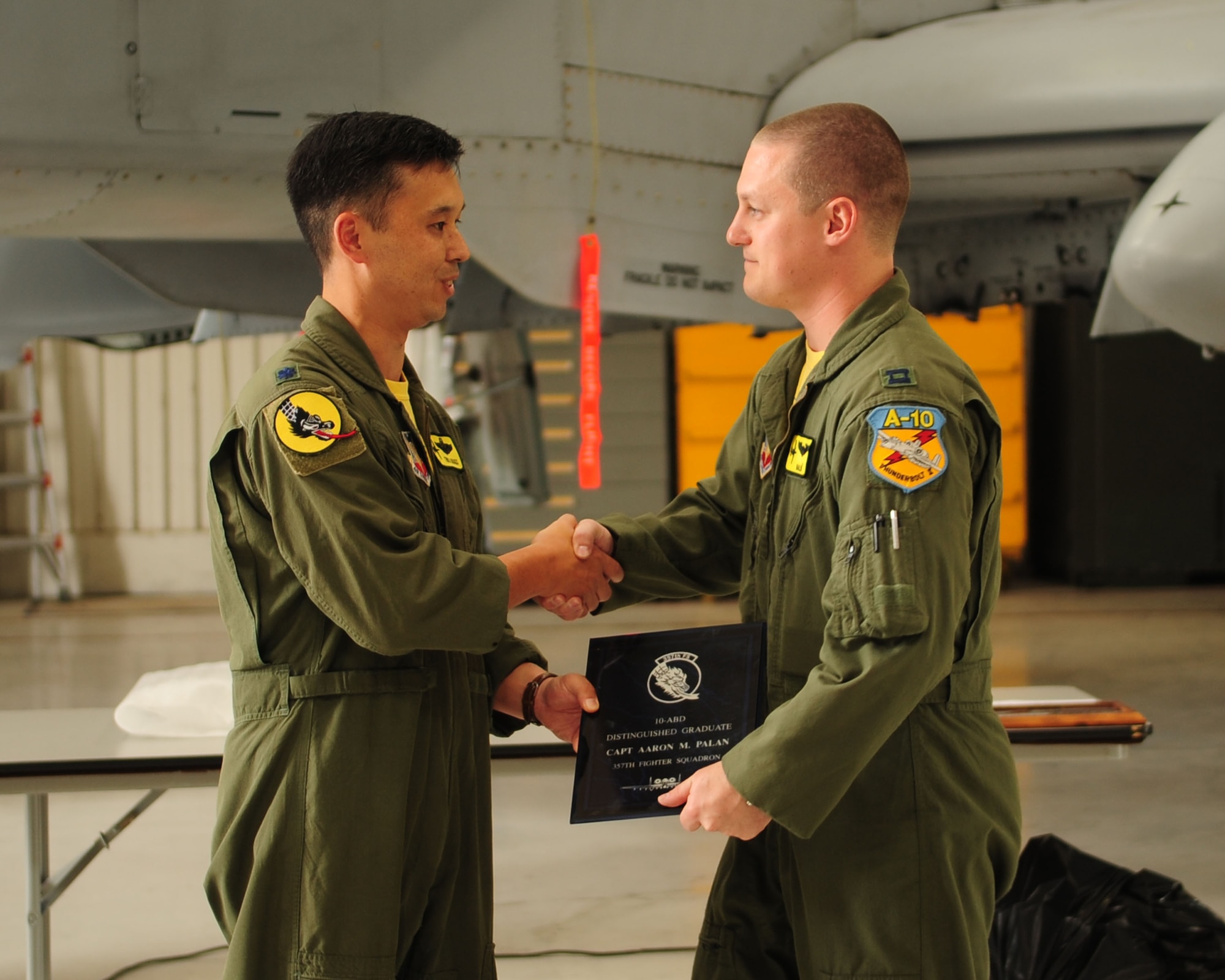Lt. Col. Richard Piazza (left), 357th Fighter Squadron commander, presents the distinguished graduate award to Capt. Aaron Palan during the graduation ceremony for class 10-ABD here July 16. The distinguished graduate is jointly chosen by the squadron commander, director of operations and flight commanders. Captain Palan, who also received the academic award, is assigned to the 75th Fighter Squadron at Moody Air Force Base, Ga. (U.S. Air Force photo/Airman 1st Class Jerilyn Quintanilla)
