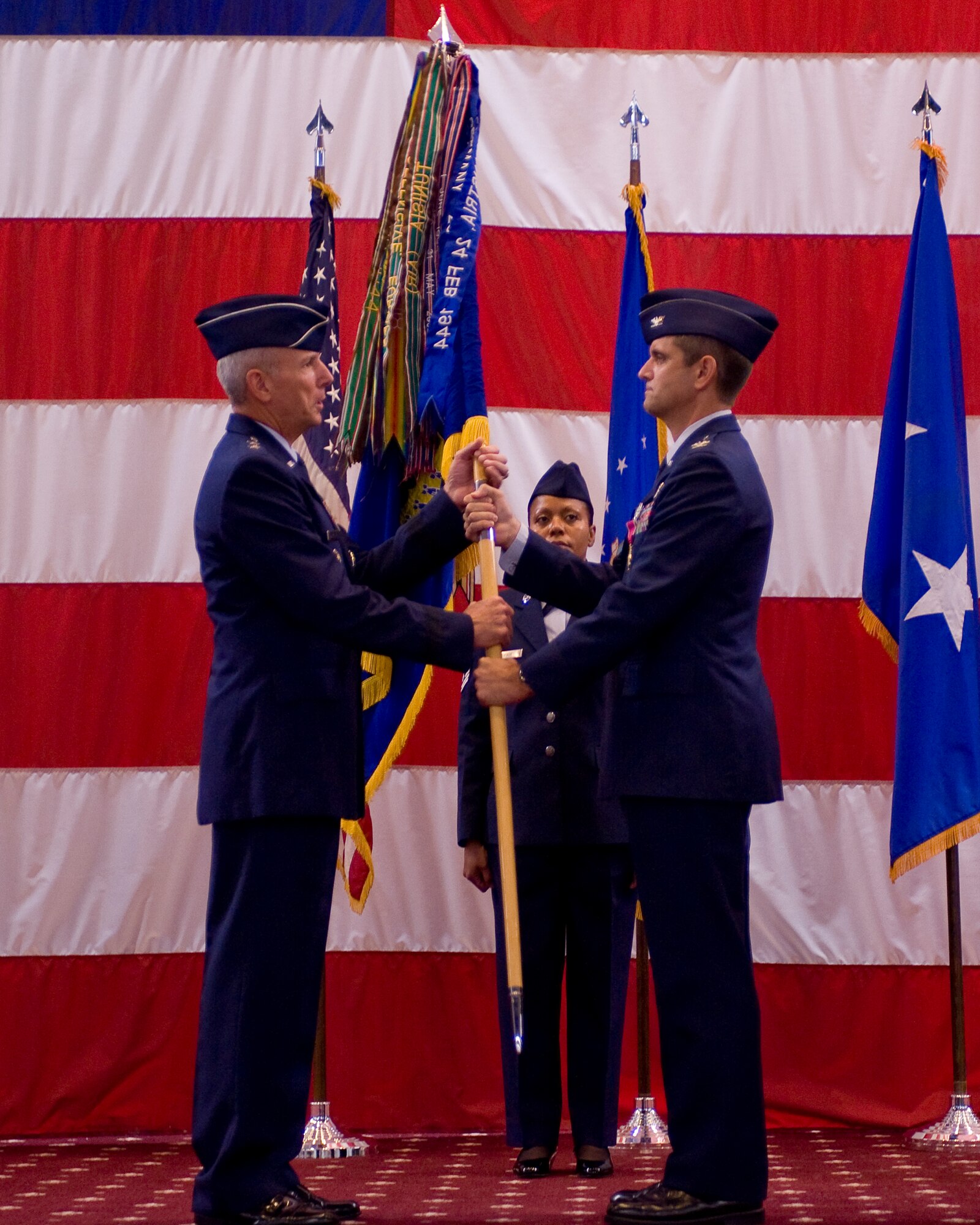 BARKSDALE AIR FORCE BASE, La. -- Col. Steven Basham (right), passes the 2d Bomb Wing guidon to Maj. Gen. Floyd Carpenter, Eighth Air Force commander, to signify his relinquishment of command during the wing change-of-command ceremony July 19. The passing of command is one deeply rooted in military tradition, dating back to the Norman Conquest of England. It serves as a visible means of handing the reins of command to the new commander. As the unit flag or guidon is exchanged, it represents the responsibility associated with the unit being surrendered and accepted. Colonel Basham relinquished command to Colonel Timothy Fay. (U.S. Air Force photo by Senior Airman Chad Warren)(RELEASED)