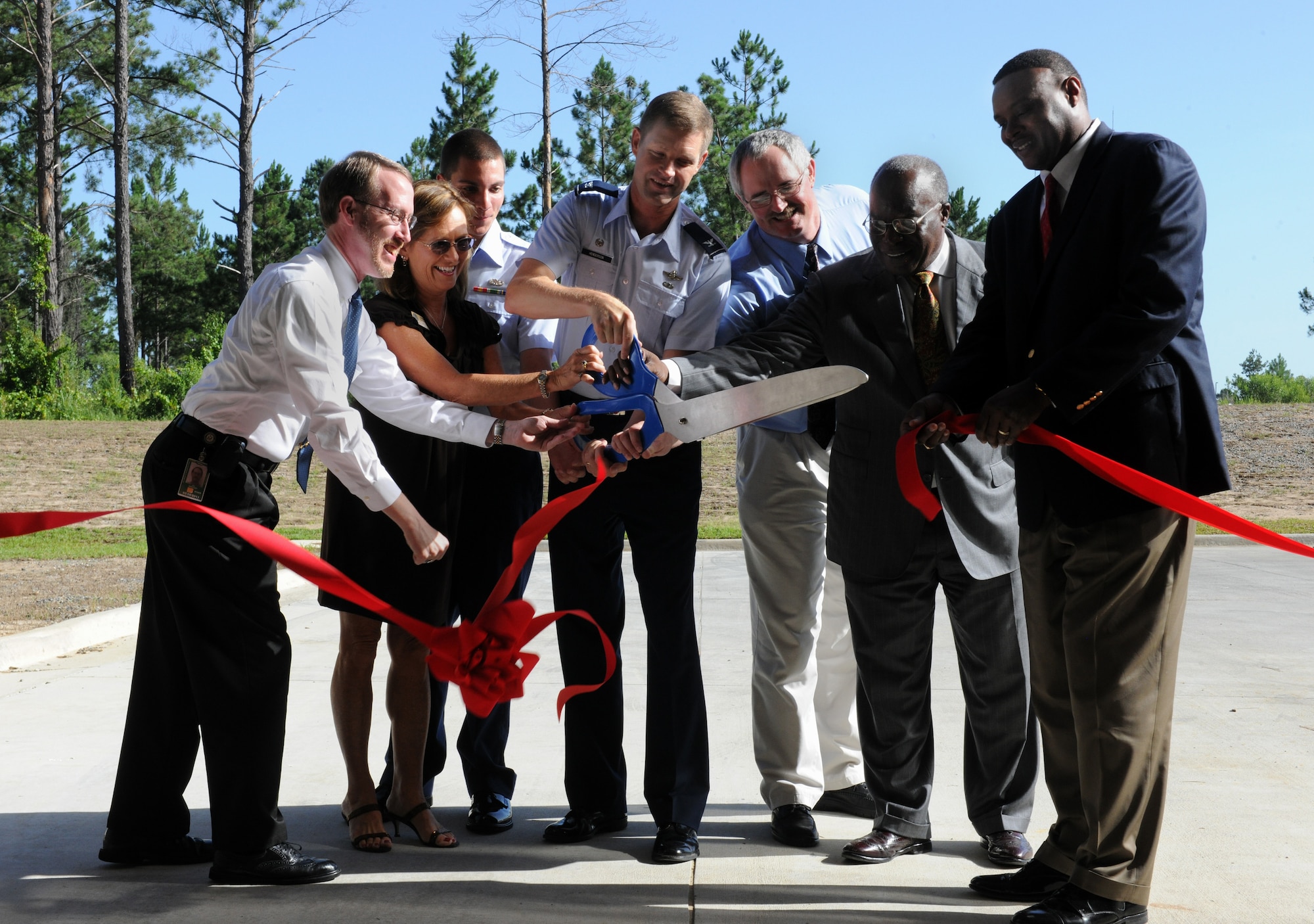 MOODY AIR FORCE BASE, Ga. -- Col. Gary Henderson, 23rd Wing commander, cuts the ceremonial ribbon with Debbie Cannon, U.S. Senator regional representative, during the TF-34 Engine Repair Facility ribbon-cutting ceremony here July 16. Other members from Moody and community leaders also assisted in cutting the ribbon. (U.S. Air Force photo by Airman 1st Class Benjamin Wiseman/RELEASED)