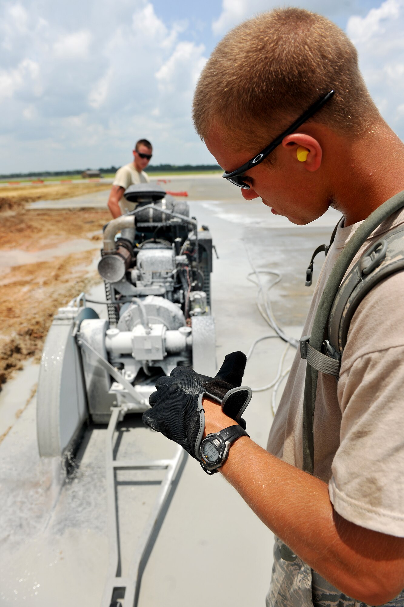 MOODY AIR FORCE BASE, Ga. -- Airman 1st Class Timothy Sackett, 823rd RED HORSE Squadron pavement equipment journeyman, guides a concrete saw for Airman 1st Class Kendall Drake, 823rd RHS pavement equipment journeyman, here July 15. Concrete saws are powered by gasoline, hydraulic or pneumatic pressure, or electric motors, and use cold water to keep the blades cooled to prolong their life and reduce dust. (U.S. Air Force photo by Airman 1st Class Joshua Green/RELEASED)
