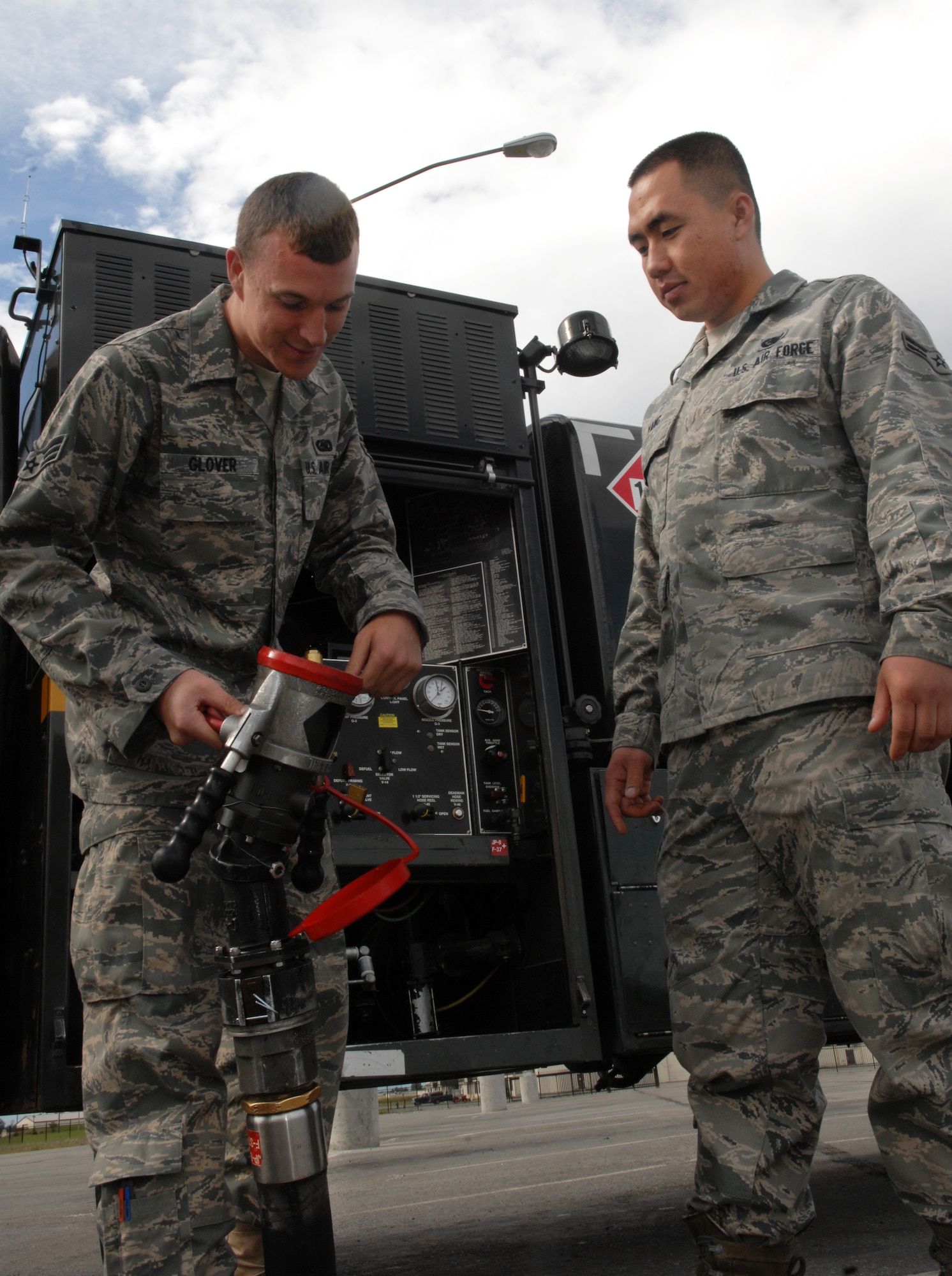 JOINT BASE ELMENDORF-RICHARDSON, Alaska -- Senior Airman William Glover (left) walks Airman 1st Class Tou Yang (right) through a fuel nosel inspection July 8. Airman Glover and Yang are 3rd Logistics Readiness Flight, fuels distribution operators.
