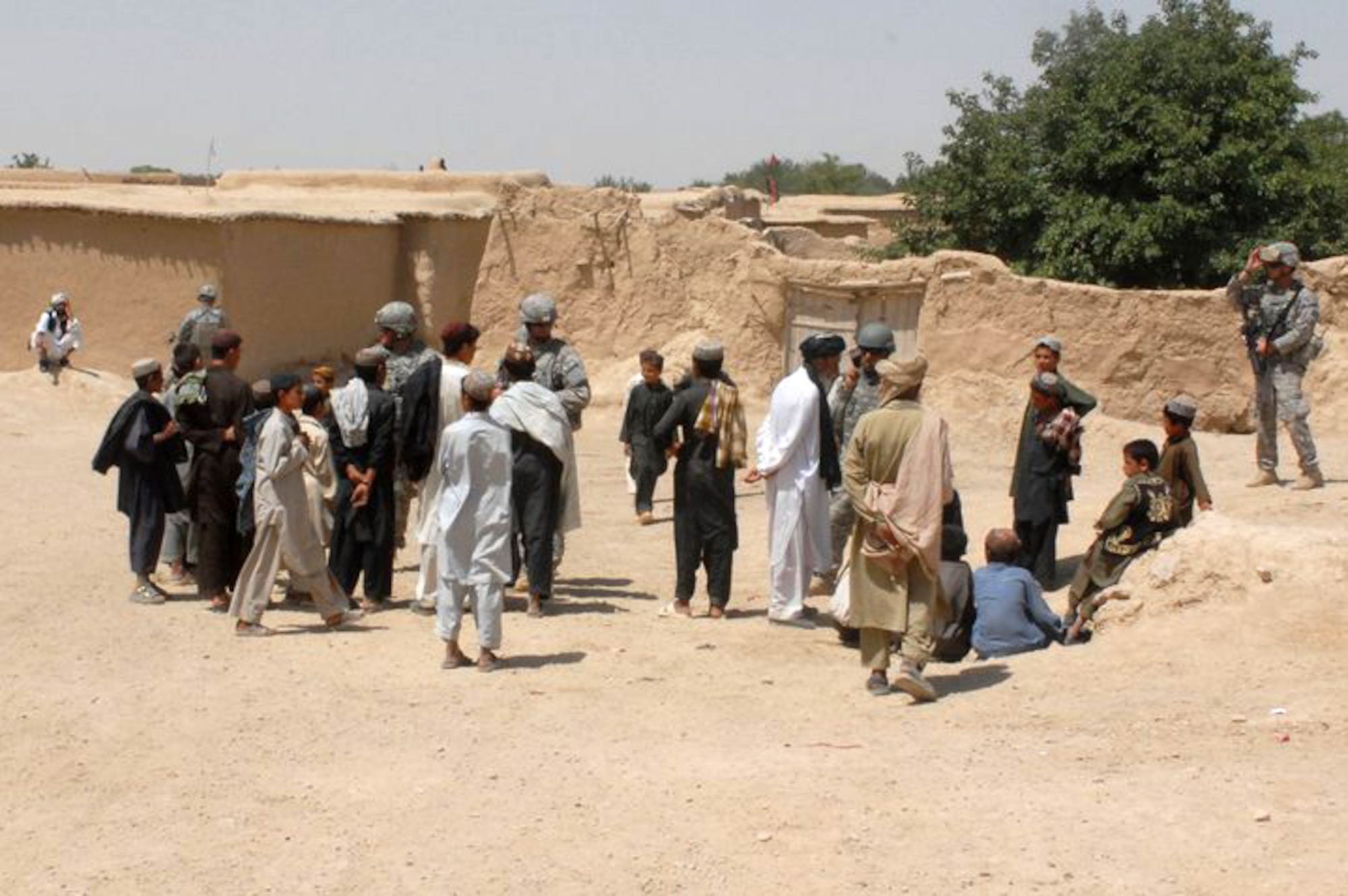 Villagers near Qalat City in southern Afghanistan talk with members of the Arkansas National Guard's Agriculture Development Team. The ADT visits local villages near their forward operating base under a program it calls Operation Know Your Neighbor. The agriculture specialists talk with villagers about farming issues, crop and animal disease and provide assistance and consulting to improve farming education and production in Zabul Province. (Photo by Lt. Col. Keith Moore/ADT Public Affairs Officer)