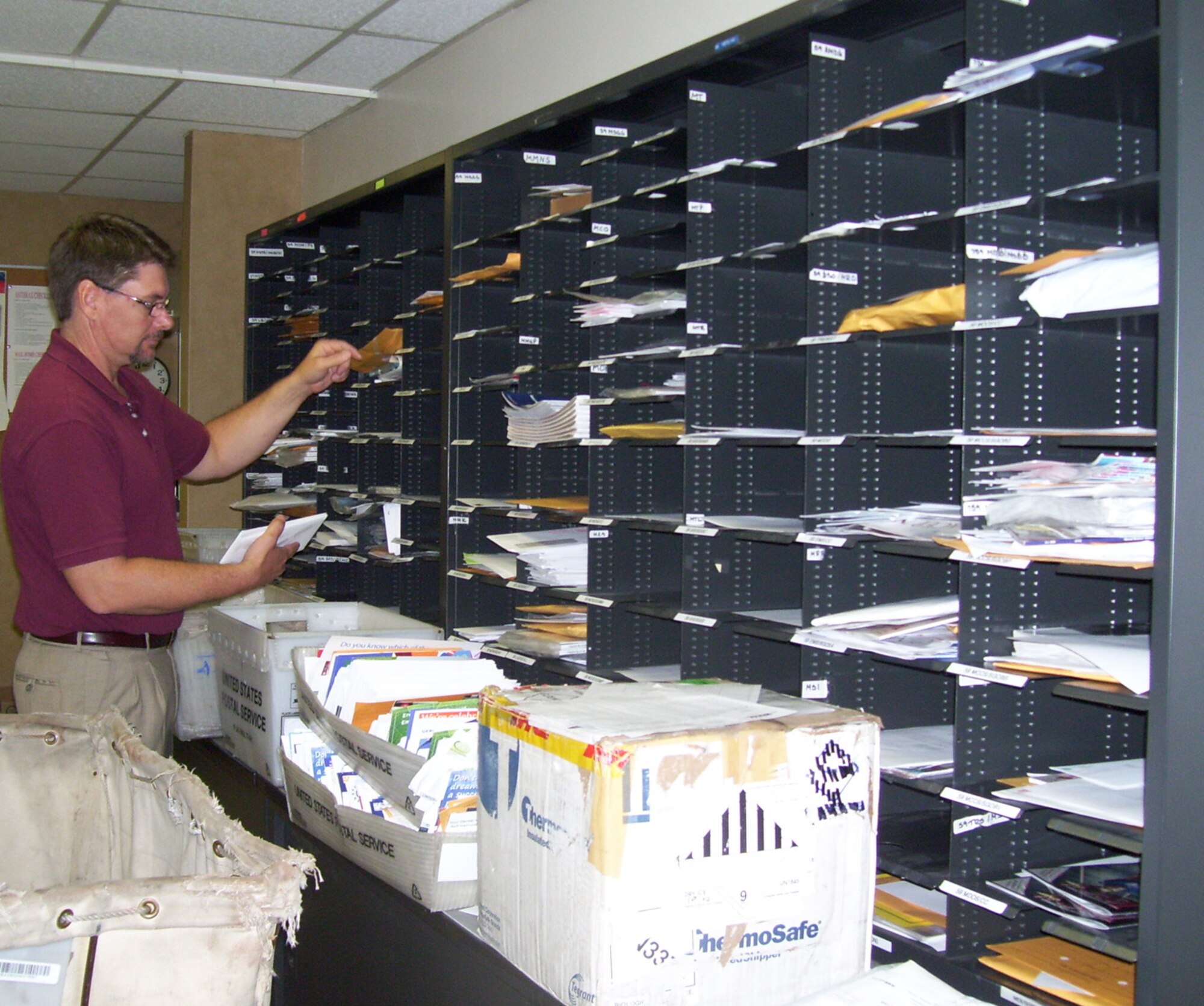 Mr. Scott Davis, Activity Distribution Office assistant manager at Wilford Hall Medical Center, Lackland Air Force Base, Texas, distributes incoming 59th Medical Wing mail July 19. The ADO processes nearly 29,000 incoming and outgoing packages and letters every month. (U.S. Air Force photo by Sue Campbell)