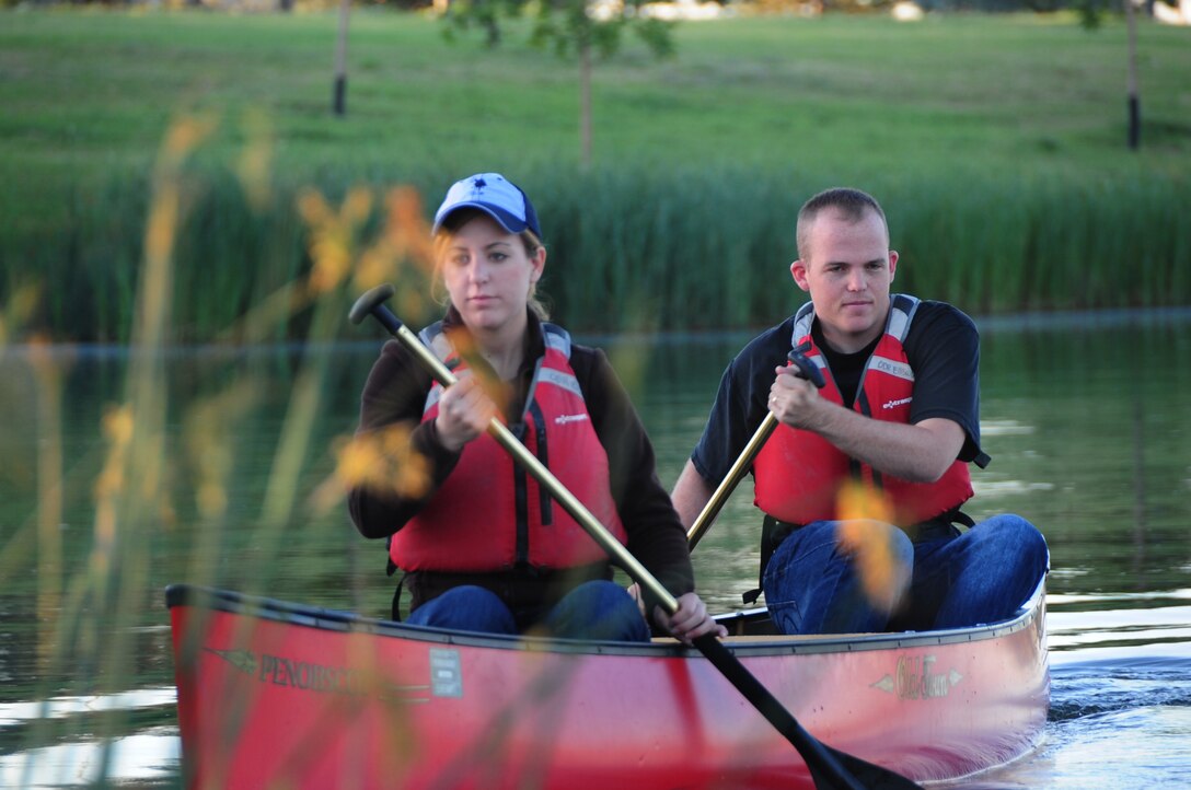 ELLSWORTH AIR FORCE BASE, S.D. -- (Left to right) Airmen 1st Class Hayley Carlson, 28th Medical Operations Squadron occupational therapy technician and Corey Hook, 28th Bomb Wing photographer, row their canoe around Bandit Lake at Ellsworth Air Force Base, S.D., July 15.  When out on a boat it is important for everyone to always wear a properly fitted life-jacket while on the vessel. (U.S. Air Force photo/Airman 1st Class Anthony Sanchelli)