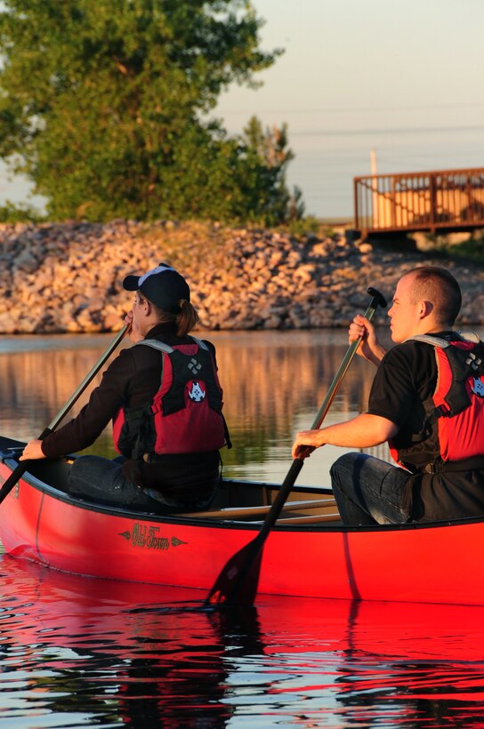 ELLSWORTH AIR FORCE BASE, S.D. -- (Left to right) Airmen 1st Class Hayley Carlson, 28th Medical Operations Squadron occupational therapy technician and Corey Hook, 28th Bomb Wing photographer, paddle a canoe on Bandit Lake at Ellsworth Air Force Base, S.D., July 15.  When out on the water it's important for boaters to be aware of their surroundings and wear the proper protective equipment. (U.S. Air Force photo/Airman 1st Class Anthony Sanchelli)
