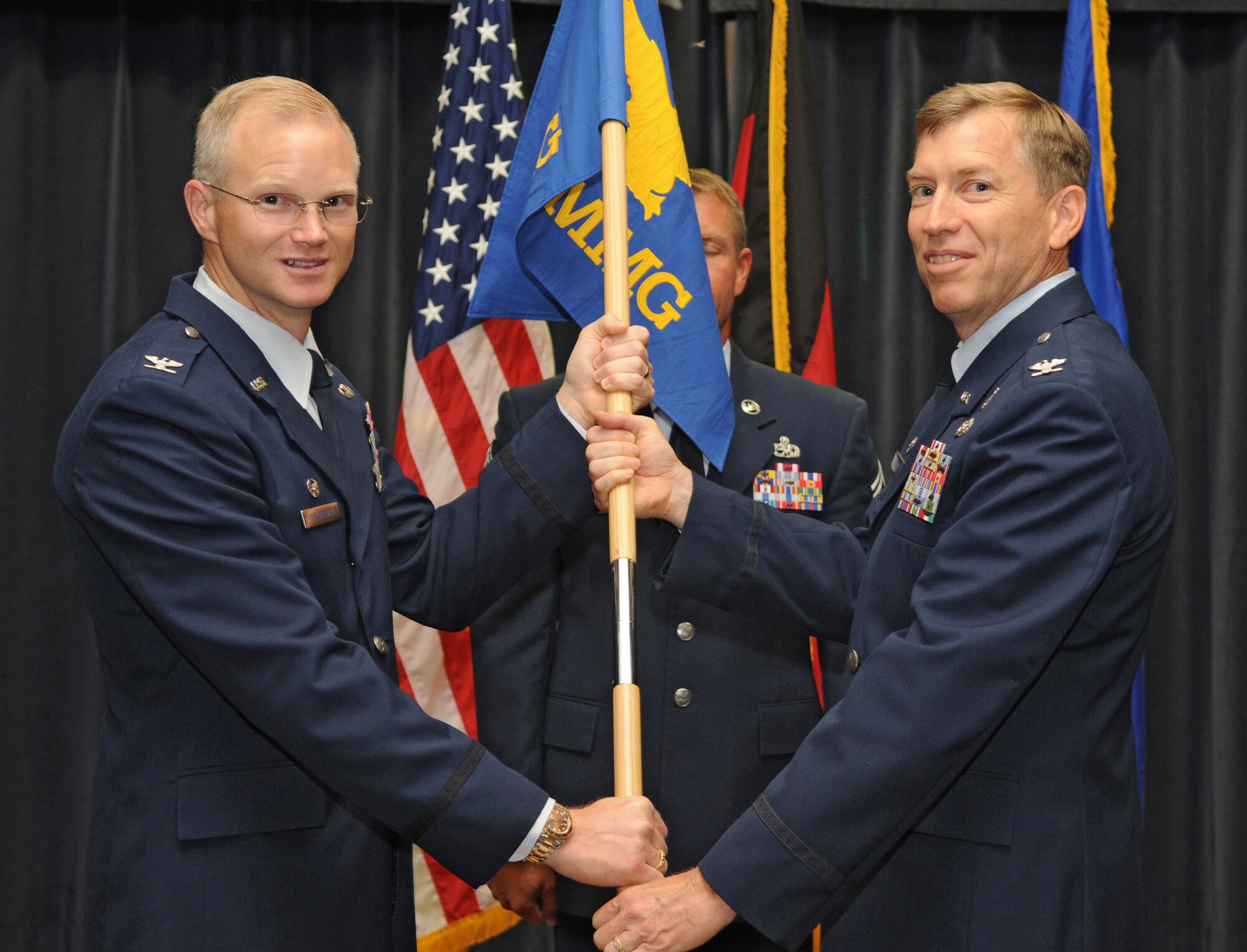 SPANGDAHLEM AIR BASE, Germany – Col. Matthew Flood, 52 Munitions Maintenance Group, accepts command of the 52nd MMG by receiving the unit’s guidon from Col. Christopher Weggeman, 52nd Fighter Wing commander, July 16. Colonel Flood took command from Col. Carey Tucker. (U.S. Air Force photo/Staff Sgt. Benjamin Wilson)