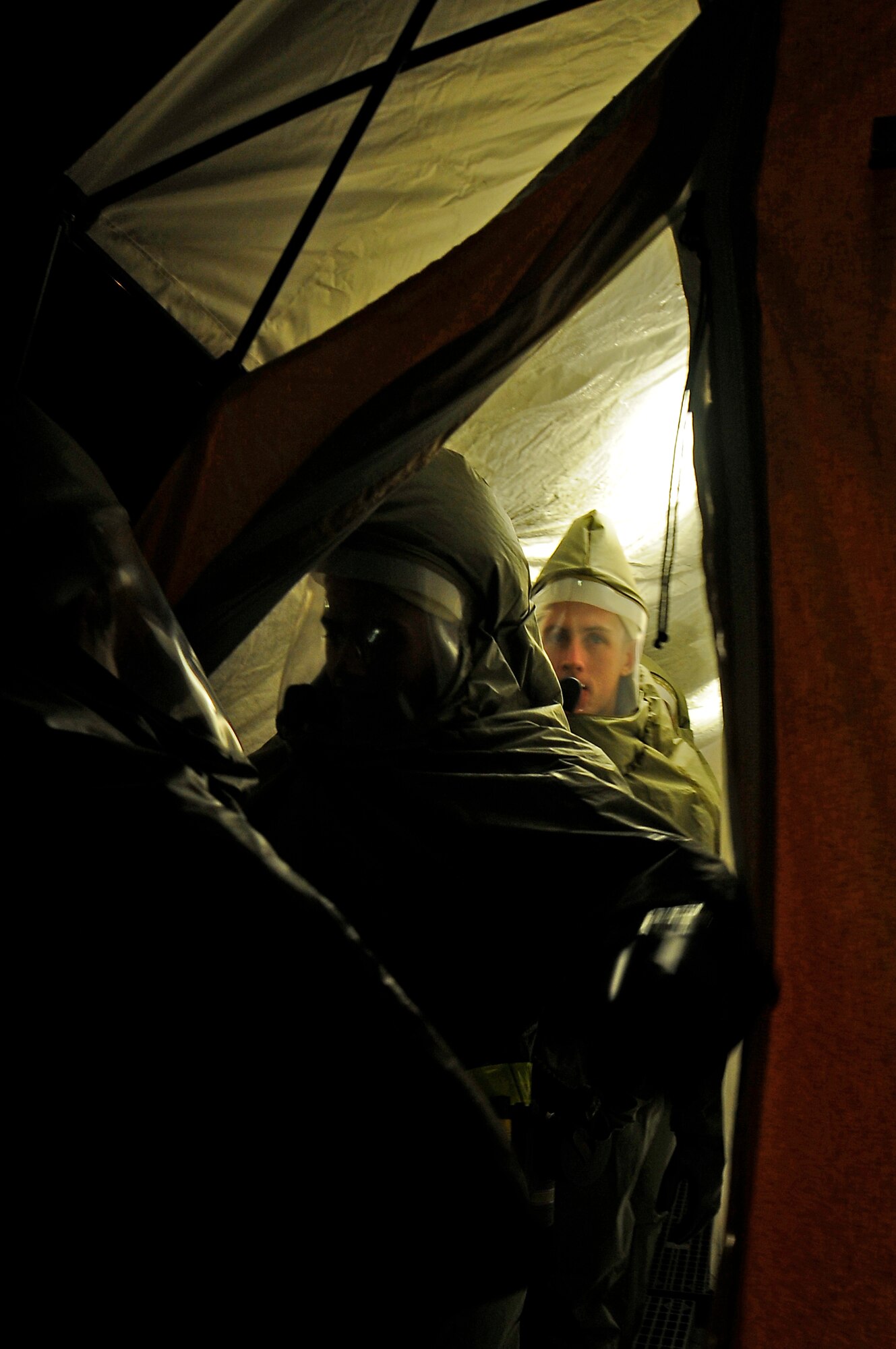 Members from the 86th Medical Group process through a decontamination tent during an Operational Readiness Exercise (ORE), Ramstein Air Base, Germany, July 19, 2010. An ORE incorporates a series of scenarios to evaluate a base's ability to execute operational duties under simulated wartime conditions. (U.S. Air Force photo by Airman 1st Class Brea Miller)