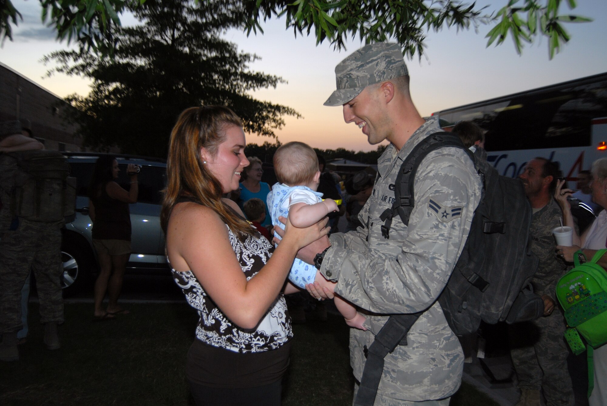 Airman 1st Class Thomas Clark, 3rd Aerial Port Squadron, meets his son, Cameron for the first time after returning from a six-month deployment to Camp Bastion on July 14. His wife, Alyssa, hands over baby Cameron so his father can hold him for the first time. (U.S. Air Force photo/Senior Airman Kris Levasseur)
