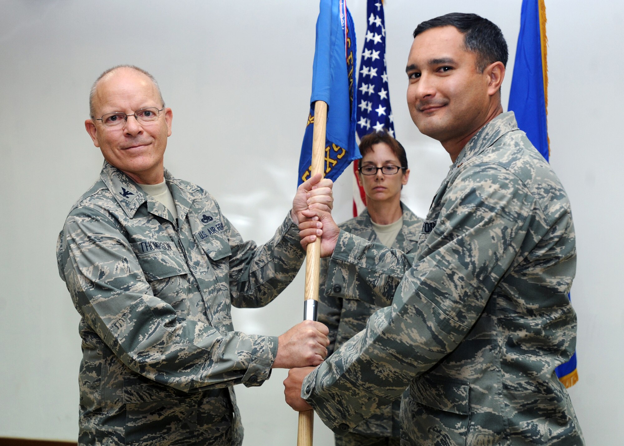 SOUTHWEST ASIA - Col. Ricky Thompson, 386th Expeditionary Maintenance Group commander, passes the 386th Expeditionary Maintenance Squadron guidon to Maj. Michael Campos, the new 386th EMXS commander, during a change-of-command ceremony at an undisclosed air base here July 15, 2010. Major Campos assumed command after Lt. Col. Maureen Carroll relinquished command. (U.S. Air Force photo by Senior Airman Laura Turner)