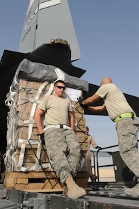 Staff Sergeants Ryan Grubaugh and Josue Balbas, both aerial porters deployed to the 451st Expeditionary Logistics Readiness Squadron, move a Low Velocity Low Cost Aerial Delivery System bundle into the cargo compartment of a C-130J assigned to the 772nd Expeditionary Airlift Squadron July 16, 2010 at Kandahar Airfield, Afghanistan.  The airdrop bundles get vital supplies to remote forward operating bases in a timely and safe manner.  (U.S. Air Force photo by Staff Sgt. Chad Chisholm/Released)