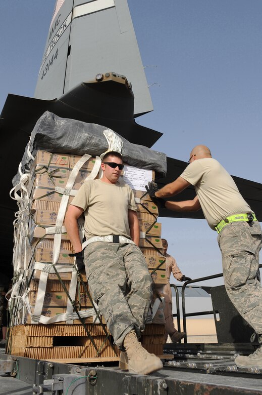 Staff Sergeants Ryan Grubaugh and Josue Balbas, both aerial porters deployed to the 451st Expeditionary Logistics Readiness Squadron, move a Low Velocity Low Cost Aerial Delivery System bundle into the cargo compartment of a C-130J assigned to the 772nd Expeditionary Airlift Squadron July 16, 2010 at Kandahar Airfield, Afghanistan.  The airdrop bundles get vital supplies to remote forward operating bases in a timely and safe manner.  (U.S. Air Force photo by Staff Sgt. Chad Chisholm/Released)