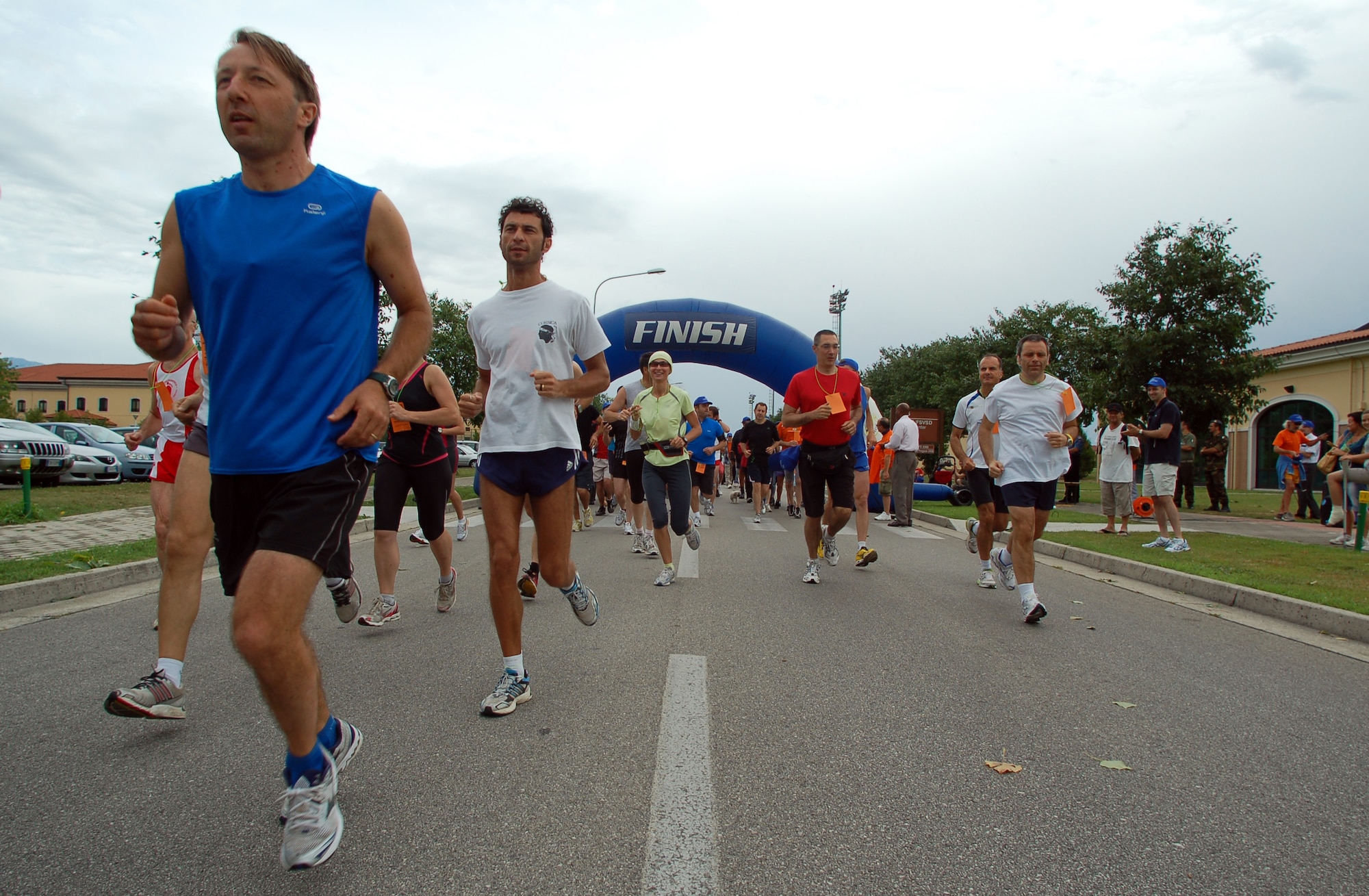 Approximately 100 Italian and American participants run the Rosario Scarpolini Association's first memorial foot race July 18 on base. With the theme, "In the Airport...For a Little Solidarity Walk," the 5K and 9k races are part of an effort to raise fund for the Rosario Scarpolini Association, an Italian organization that provides free furnished apartments to families of needy patients during care at the Center for National Cancer Institute in Aviano, Italy. (U.S. Air Force photo/Staff Sgt. Julius Delos Reyes)