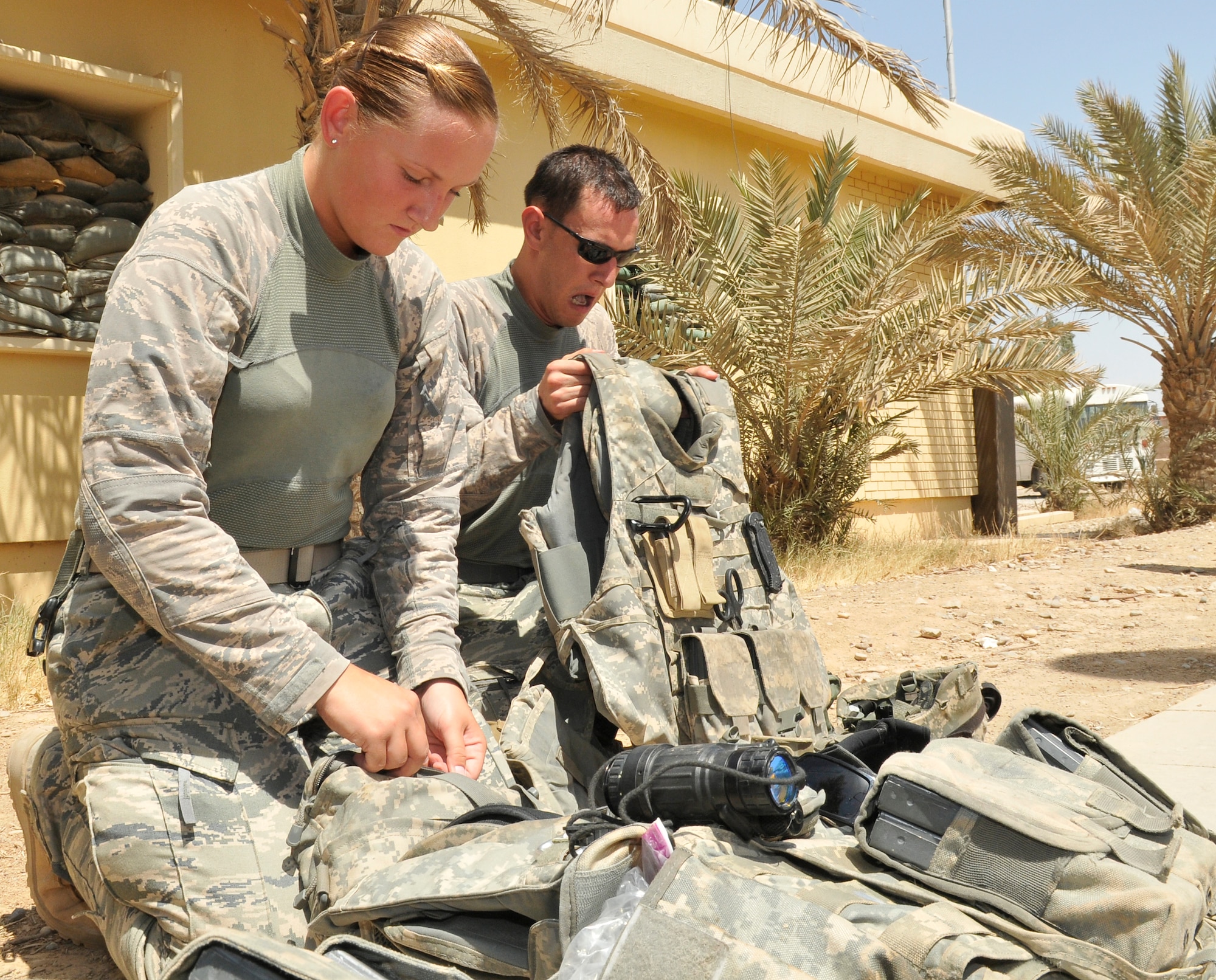 Airman 1st Class Brittany Boettger and Senior Airman Mathew Keasey, 532nd Expeditionary Security Forces Squadron defenders, prepare personal protective equipment prior to a mission July 9, 2010, Joint Base Balad, Iraq. There’s a saying, “You don’t rise to the occasion, you fall to your lowest level of training,” this is why the unit continually prepares and trains for any situation, said Capt. Capt. Michael Cohen, 532nd Expeditionary Security Forces Squadron Force Protection Patrol officer in charge. Captain Cohen is deployed from Lackland Air Force Base, Texas,  Airman Boettger is deployed from Eielson Air Force Base, Alaska, and Airman Keasey is deployed from Nellis Air Force Base, Nev. (U.S. Air Force photo/Staff Sgt. Phillip Butterfield)