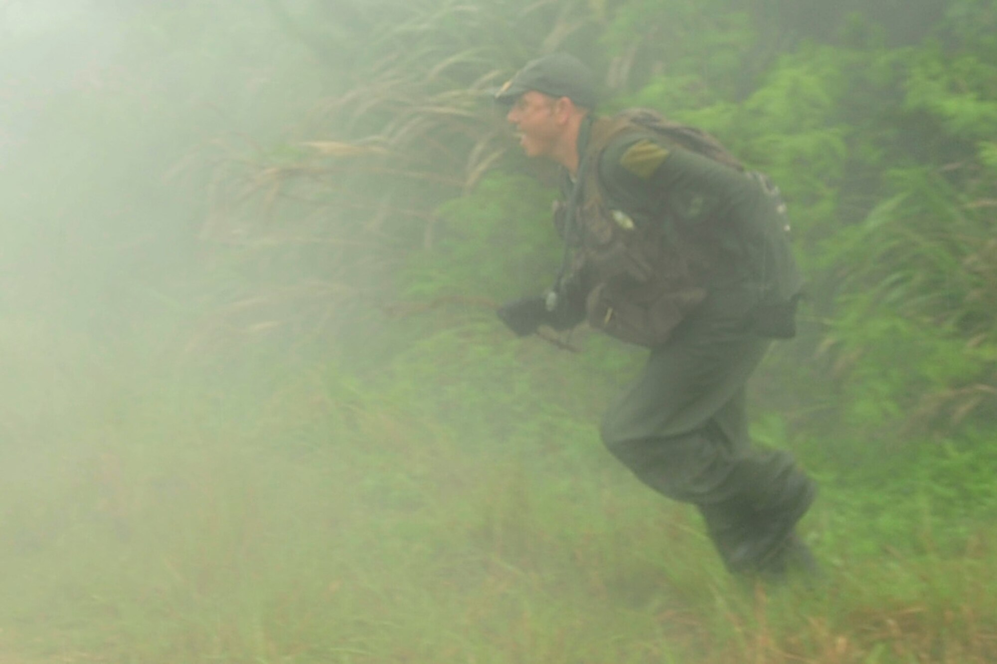 Master Sgt. John Matye, member of the 17th Special Operations Squadron, quickly runs across a road after releasing a smoke bomb to give him more cover to not be captured during a survival, evasion, resistance, and escape, or SERE, exercise at Kadena Air Base’s Area 1 July 1. Every three years aircrew members must undergo a refresher course of SERE training. (U.S. Air Force photo by Senior Airman Amanda Grabiec)