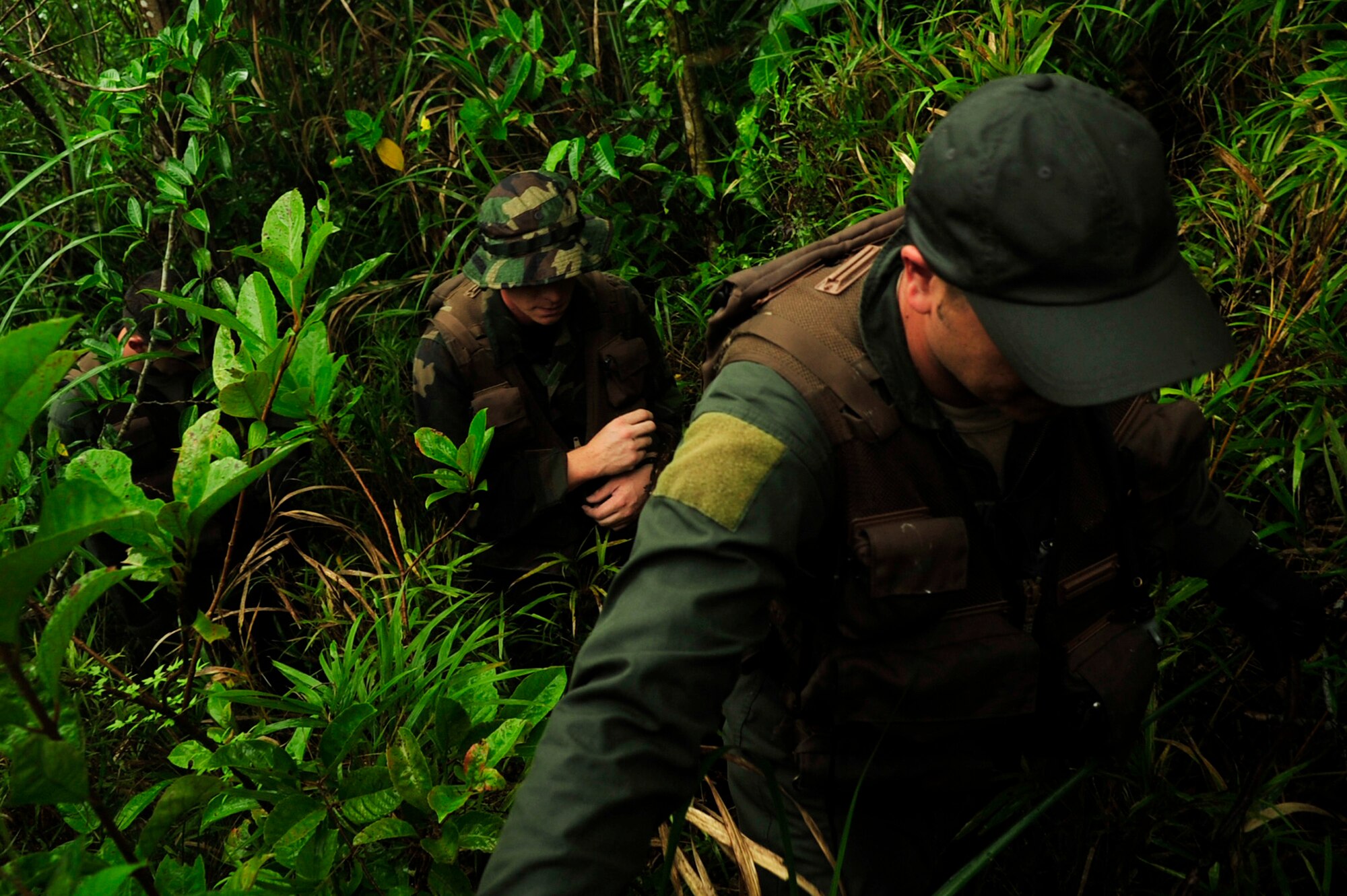 Master Sgt. John Matye (right), member of the 17th Special Operations Squadron, Staff Sgt. James Kosnosky (middle), member of the 1st Special Operations Squadron, and Airman 1st Class Michael Mendes, member or the 17th Special Operations Squadron, trek through the jungles of Area 1 during a survival, evasion, resistance, and escape exercise at Kadena Air Base July 1. Every three years aircrew members must undergo a refresher course of SERE training. (U.S. Air Force photo by Senior Airman Amanda Grabiec)
