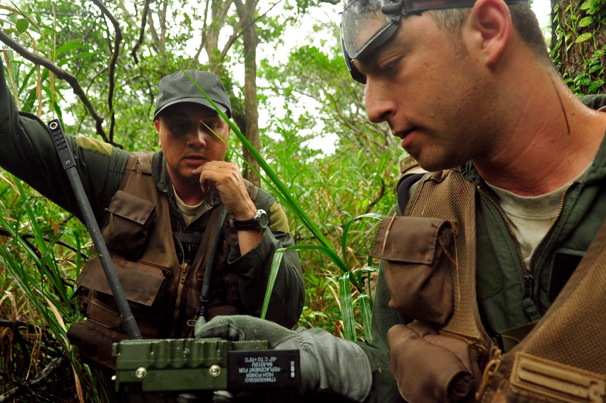 Master Sgt. John Matye (left) and Airman 1st Class Michael Mendes (right), both members of the 17th Special Operations Squadron, find the coordinates on a global positioning system to pinpoint the correct direction to travel during an exercise at Kadena Air Base’s Area 1 July 1. Every three years aircrew members must undergo a refresher course of Survival, Evasion, Resistance and Escape training. (U.S. Air Force photo by Senior Airman Amanda Grabiec)