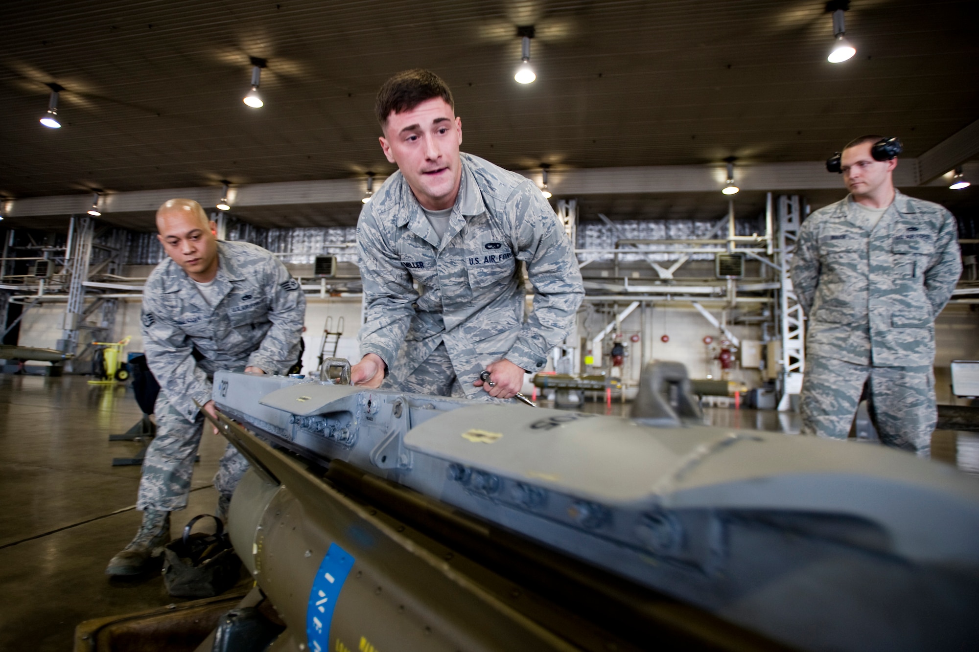 MISAWA AIR BASE, Japan -- Staff Sgt. Antonio Balayan and Airman Matthew Miller, 13th Aircraft Maintenance Unit load-crew members, attach an LAU-117 missile launcher to an AGM-65D air-to-ground missile during the weapons-load crew of the quarter competition July 16 at Hangar 911. The competition will prove who is the 35th Fighter Wing's best load crew for the months of April through June. (U.S. Air Force photo/Senior Airman Jamal D. Sutter)