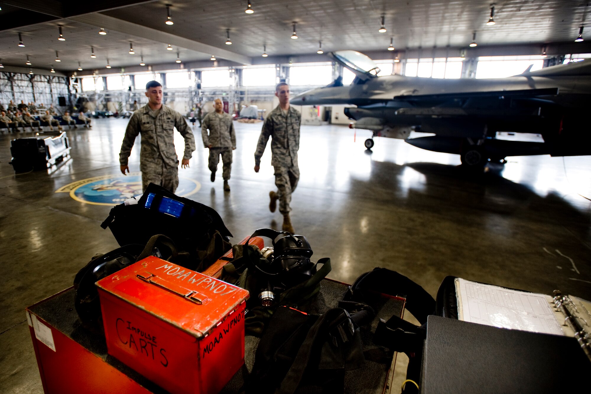 MISAWA AIR BASE, Japan -- Staff Sgt. Antonio Balayan, Airman 1st Class Paul Callahan and Airman Matthew Miller approach their tool station in preparation for the weapons-load crew of the quarter competition July 16 at Hangar 911. The Airmen are weapons-load crew members from the 13th Aircraft Maintenance Unit and were nominated by their section chiefs to compete in the event. Their final score will be pitted against a 14th Aircraft Maintenance Unit load crew currently deployed to Kunsan Air Base, South Korea. (U.S. Air Force photo/Senior Airman Jamal D. Sutter)