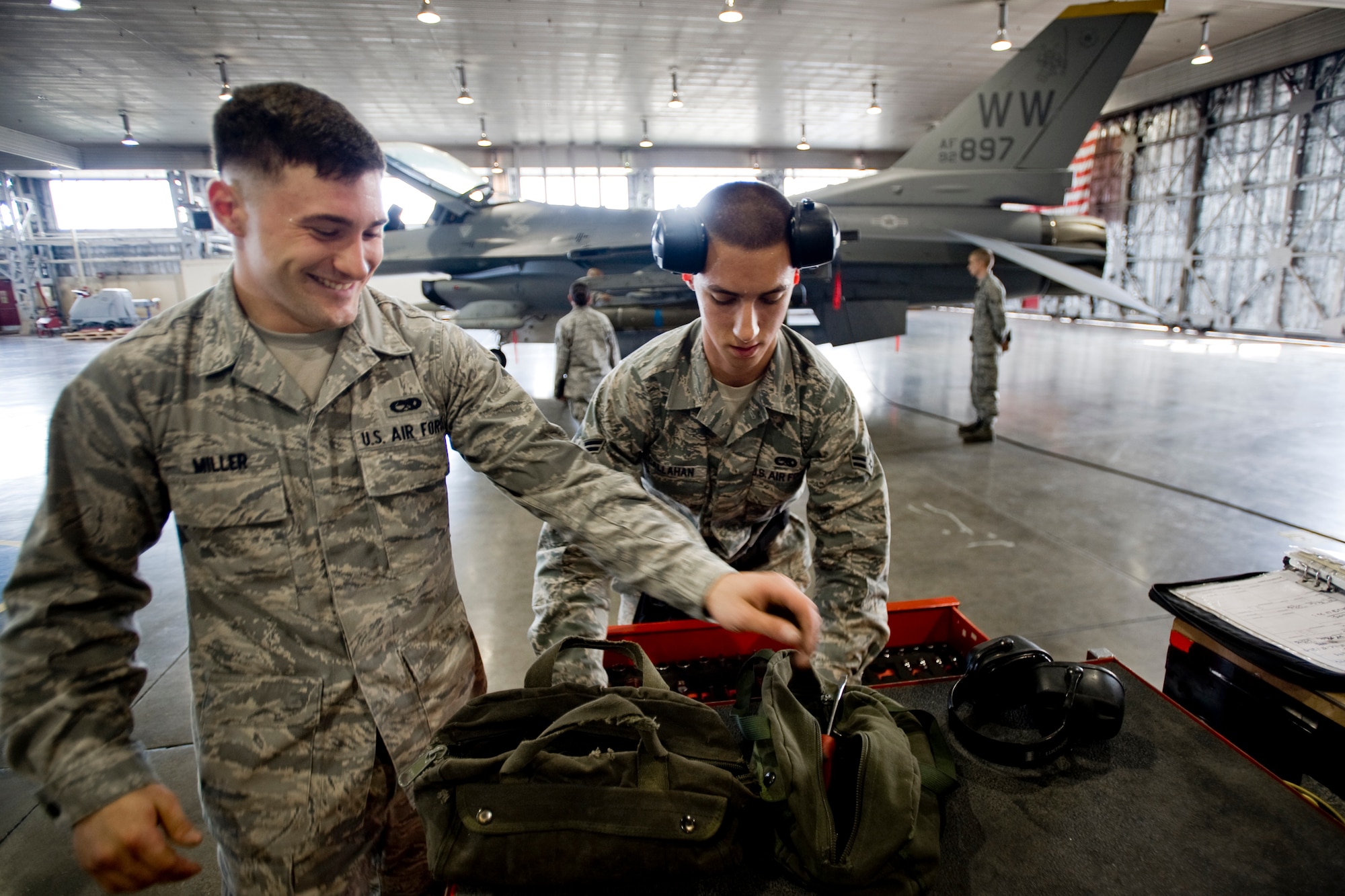 MISAWA AIR BASE, Japan -- Airman Matthew Miller shares a laugh with Airman 1st Class Paul Callahan during the weapons-load crew of the quarter competition July 16 at Hangar 911.  Despite its competitive nature, the event is designed to boost morale throughout the unit as teammates work together and co-workers cheer them on. (U.S. Air Force photo/Senior Airman Jamal D. Sutter)