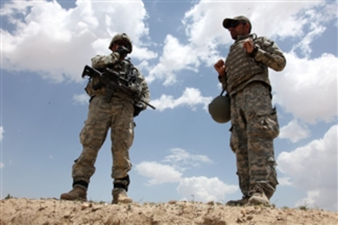 U.S. Army 1st Lt. Nick Eidemiller (left) communicates with his platoon by radio while his interpreter stands next to him during a mission in Jaghato District, Wardak province, Afghanistan, on July 8, 2010.  Eidemiller is assigned to 1st Platoon, Able Company, 1st Battalion, 503rd Infantry Regiment, 173rd Airborne Brigade Combat Team.  