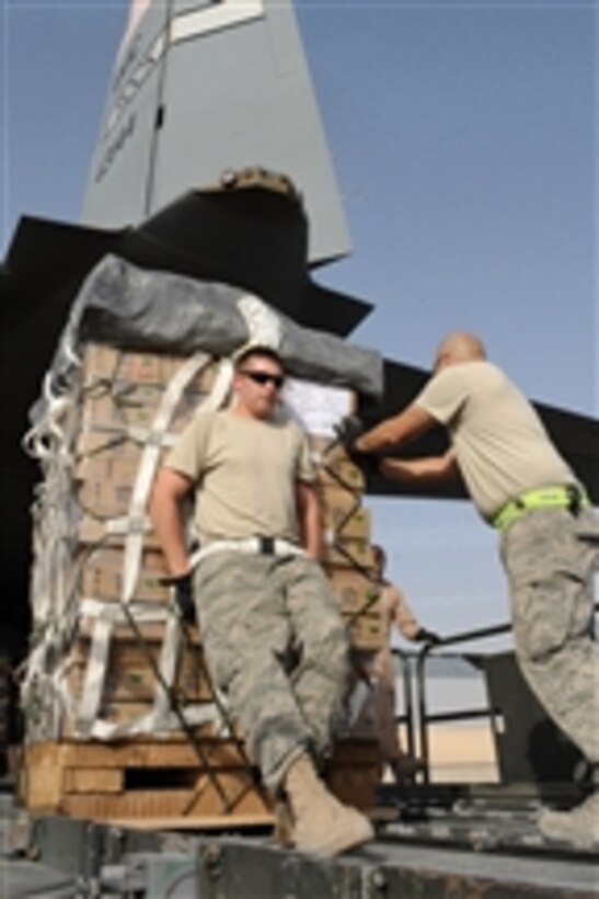U.S. Air Force Staff Sgts. Ryan Grubaugh and Josue Balbas move a low cost aerial delivery system bundle into the cargo compartment of a C-130J Hercules aircraft at Kandahar Airfield in Afghanistan on July 16, 2010.  The airmen are both aerial porters deployed to the 451st Expeditionary Logistics Readiness Squadron and the aircraft is assigned to the 772nd Expeditionary Airlift Squadron.  Low cost aerial delivery system bundles are designed to provide supplies to remote forward operating bases in a timely, safe and cost-efficient manner.  