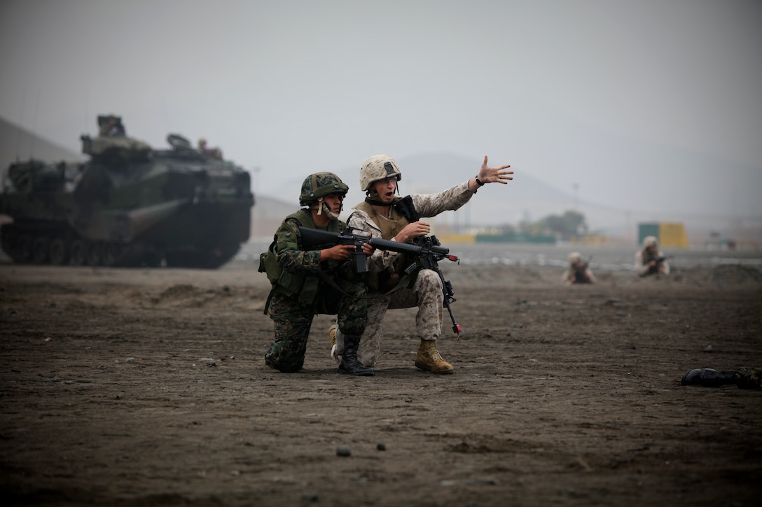 U.S. Marine Corps Capt. Solon McGill from Special Purpose Marine Air-Ground Task Force 24 (Golf Co, 2/24) raids a building next to a Peruvian officer during multinational amphibious beach assault training exercise in Ancon, Peru on July 19, 2010 The unit was deployed in support of operation Partnership of the Americas/Southern Exchange, a combined amphibious exercise designed to enhance cooperative partnerships with maritime forces from Argentina, Mexico, Peru, Brazil, Uruguay, and Colombia.   (U.S. Marine Photo photo by Cpl Brian J. Slaght/Released)