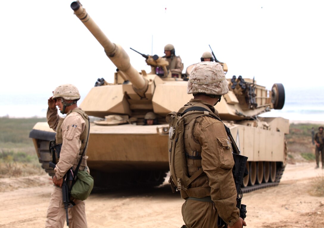 Reserve Marines with Alpha Company, 4th Tank Battalion, San Diego, guard and direct tanks during an amphibious land-and-assault scenario at Camp Pendleton’s Red Beach, July 19. Fourth Tank is making the most of their required annual training by learning how to apply their job to a war-like situation. More than 70 service members came together for this 10-day activity that began on the shore line of Red beach and is scheduled to end at the 41 Area, July 26.