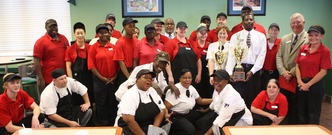 The civilian team of food service specialists and cooks with Mess Hall 211 gather for a photo, July 20, after the were awarded the Best Mess Hall of the Quarter, for being the best full food service.