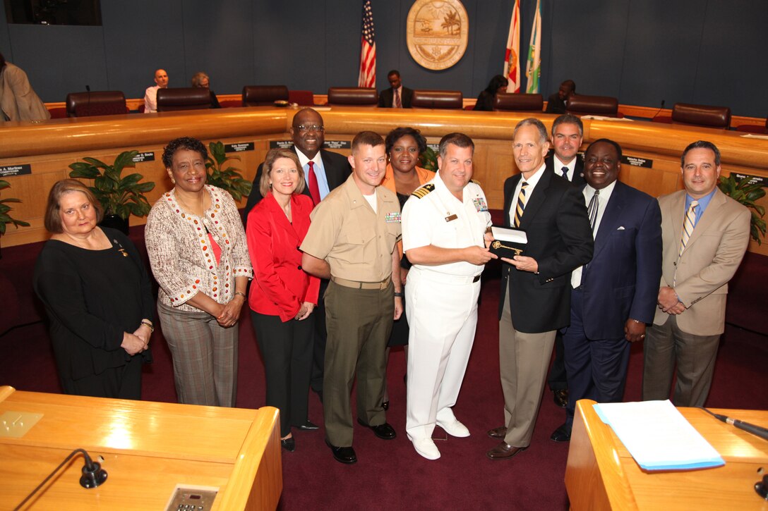 (Center) Navy Capt. Jeff Amick, commanding officer of USS Iwo Jima, and Miami-Dade County Mayor Carlos Alvarez hold the key to Miami-Dade County, July 20, 2010. Amick and Lt. Col. Chris S. Richie, the Special Purpose Marine Air-Ground Task Force Continuing Promise 2010 commanding officer, were recognized for upcoming humanitarian relief efforts to the Caribbean, Central and South America.