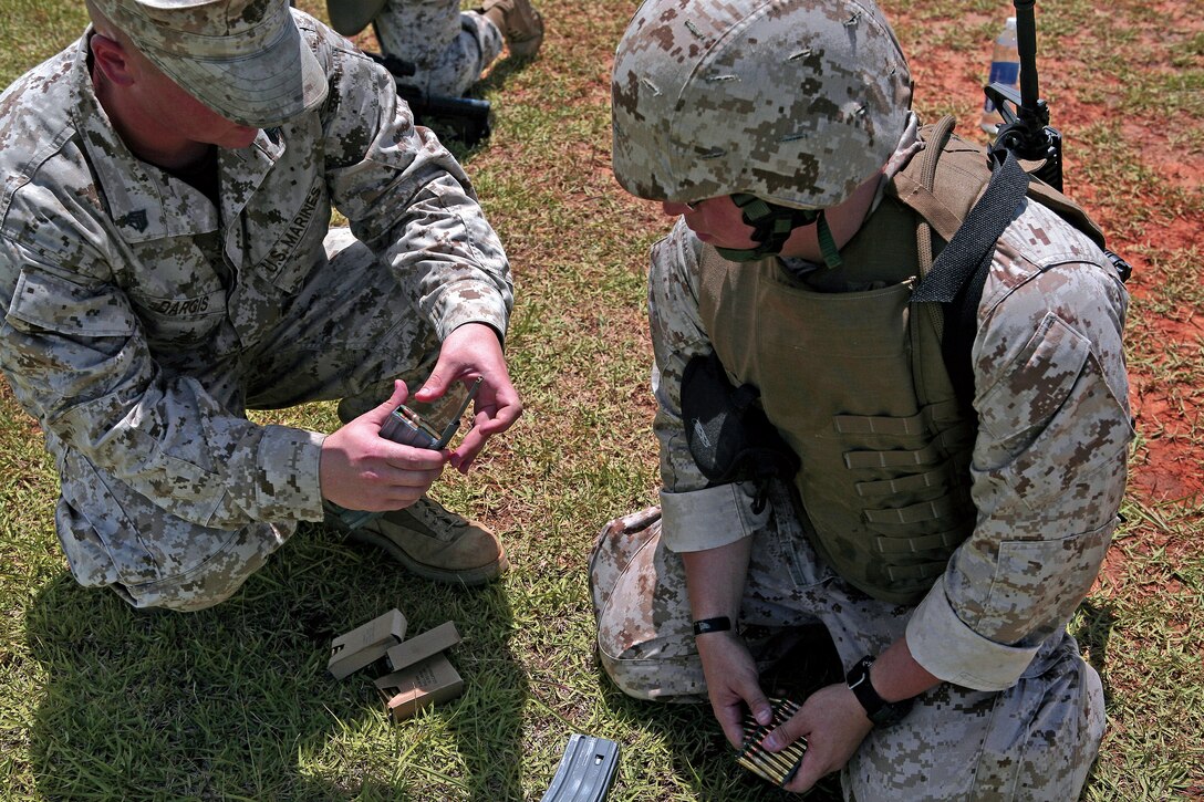 Sgt. Joshua Dargis, a weapons coach and chemical, biological, radiological and nuclear defense specialist at 3rd Medical Battalion, Combat Logistics Regiment 35, 3rd Marine Logistics Group, teaches Petty Officer 2nd Class Anthony Colon, a hospital corpsman with Bravo Forward Surgical, 3rd Med. Bn., how to use a speed reloader at a familiarization range on Camp Hansen, July 20.