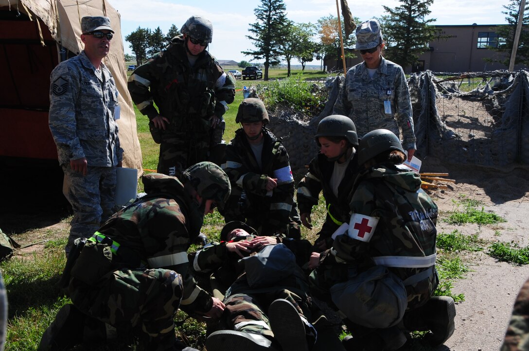 ELLSWORTH AIR FORCE BASE S.D. -- Airman 1st Class Corey Hook, 28th Bomb Wing photographer, lies on the ground with a simulated open abdominal wound, while Airmen from the 28th Medical Operations Squadron practice self-aid buddy care during a phase II operational readiness exercise, July 20.  The phase II ORE tests Airmen in a simulated deployed environment. (U.S. Air Force photo/Airman 1st Class Anthony Sanchelli)